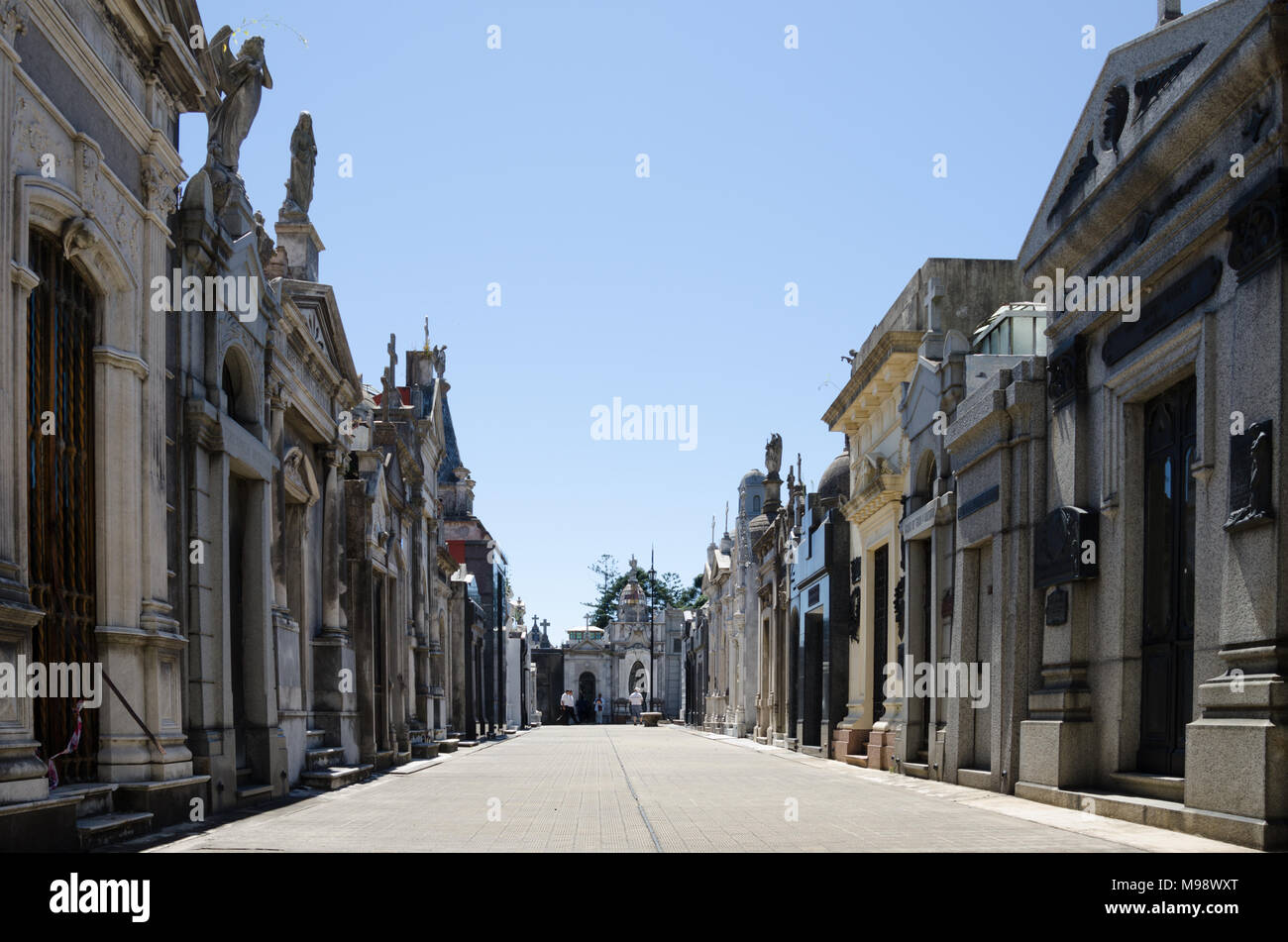 View between mausoleums in old historical cemetery, with city backdrop - at Recoleta cemetery, Buenos Aires. Stock Photo