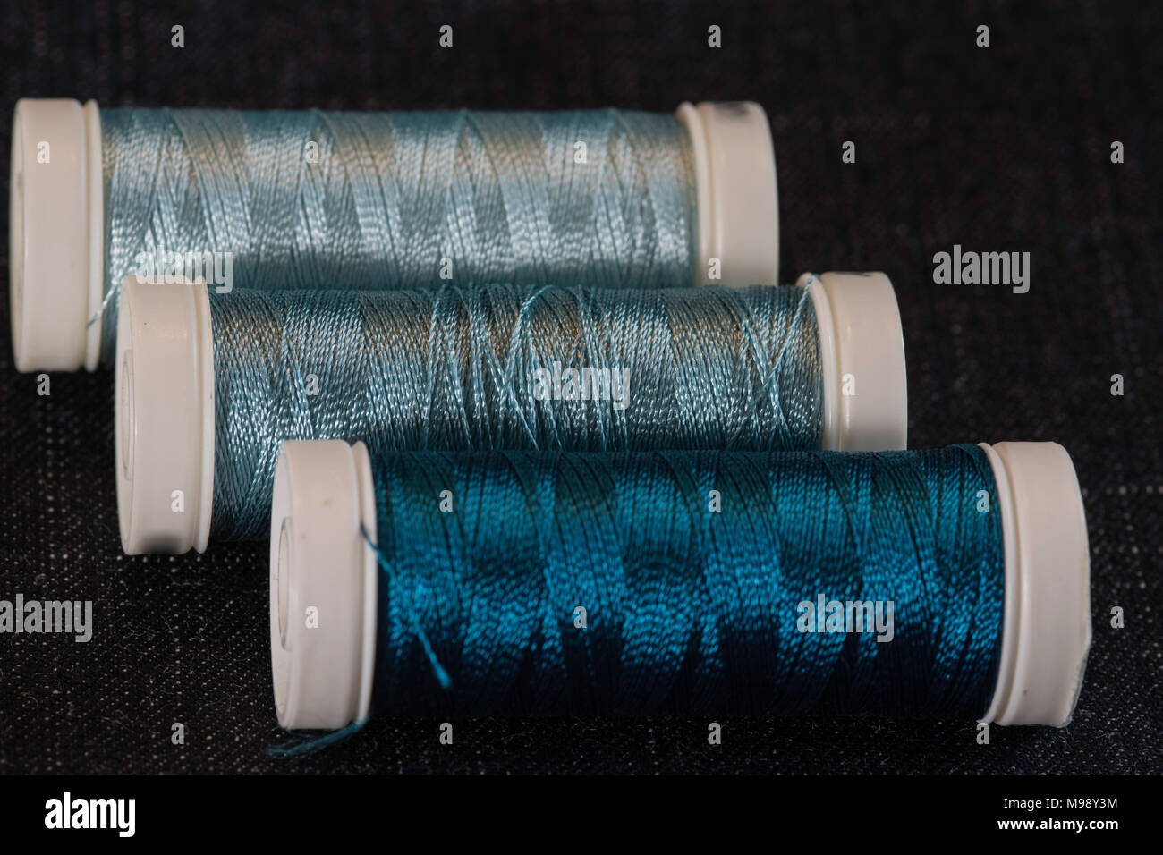 assorted spools of teal blue sewing thread Stock Photo