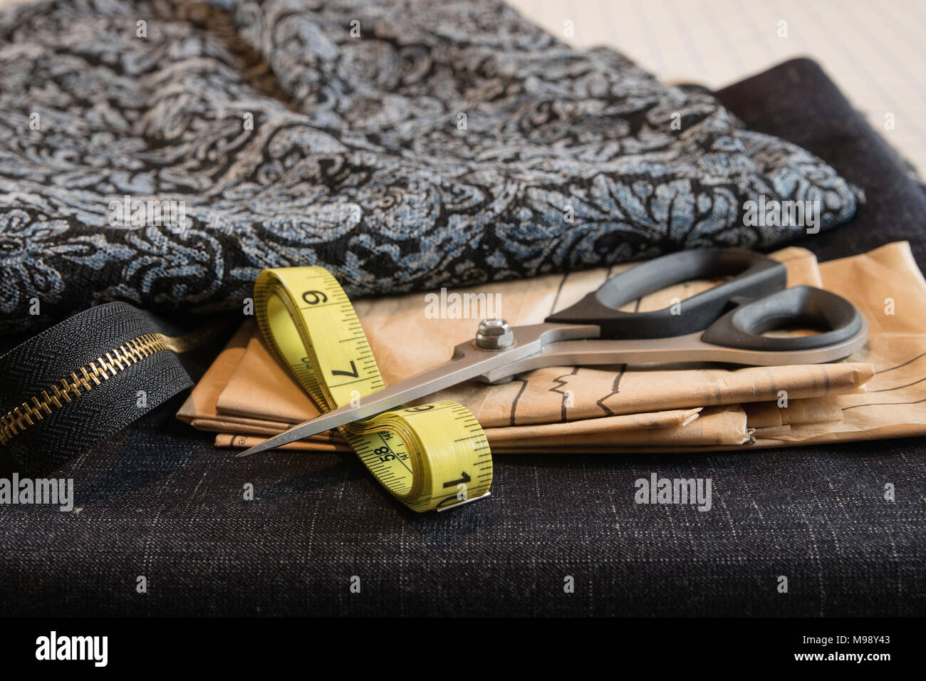 sewing with blue fabrics, scissors, pattern, tape measure and zipper