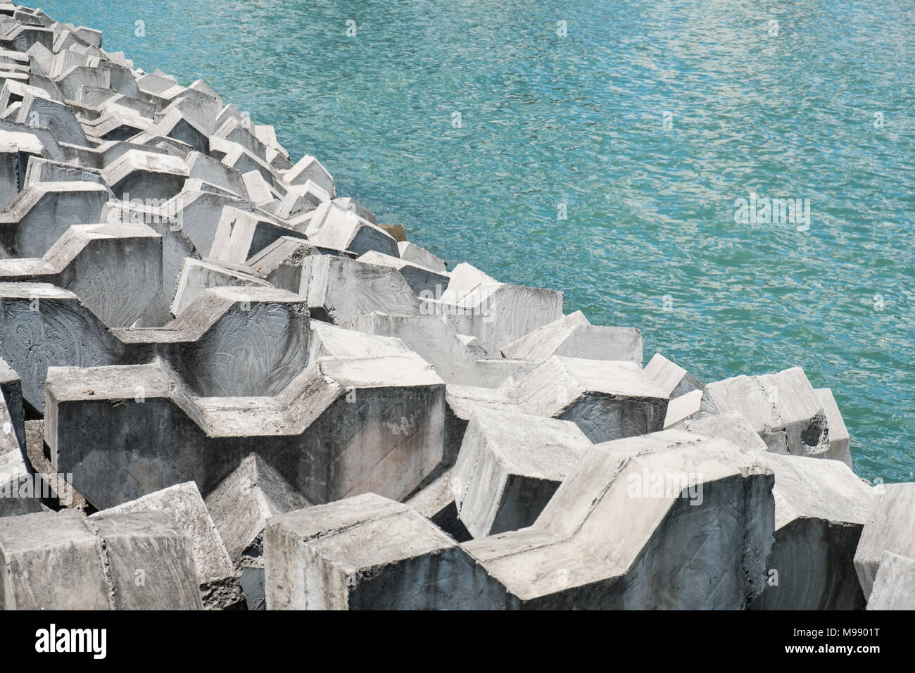 concrete wavebreaker on coast - huge cement blocks on ocean waterside