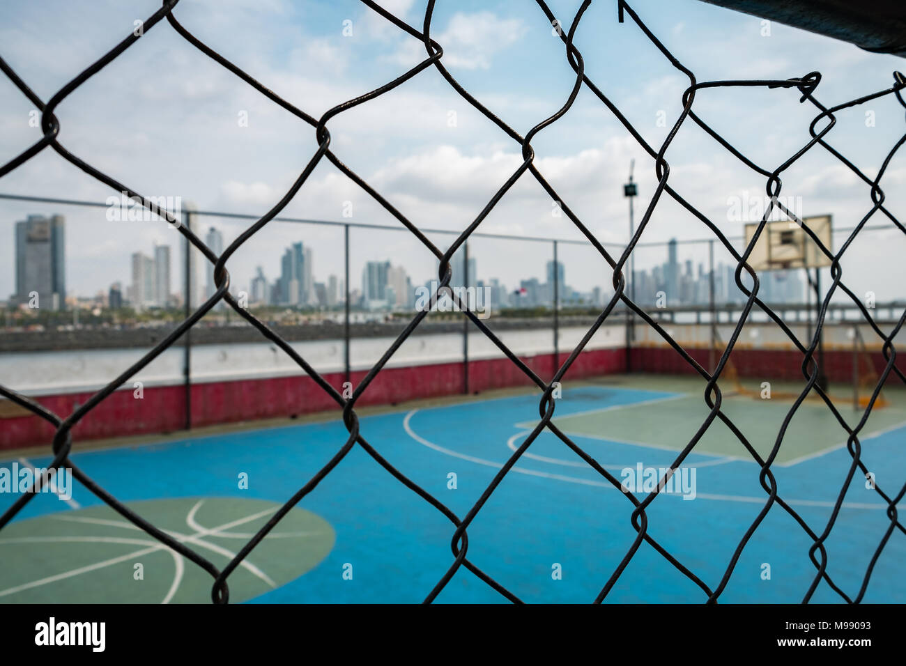 basketball court behind fence with city skyline background sport