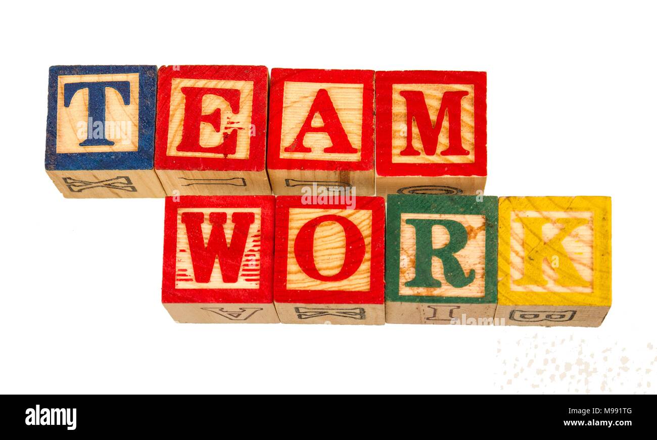 The term team work visually displayed on a white background using colorful wooden toy blocks image in landscape format Stock Photo