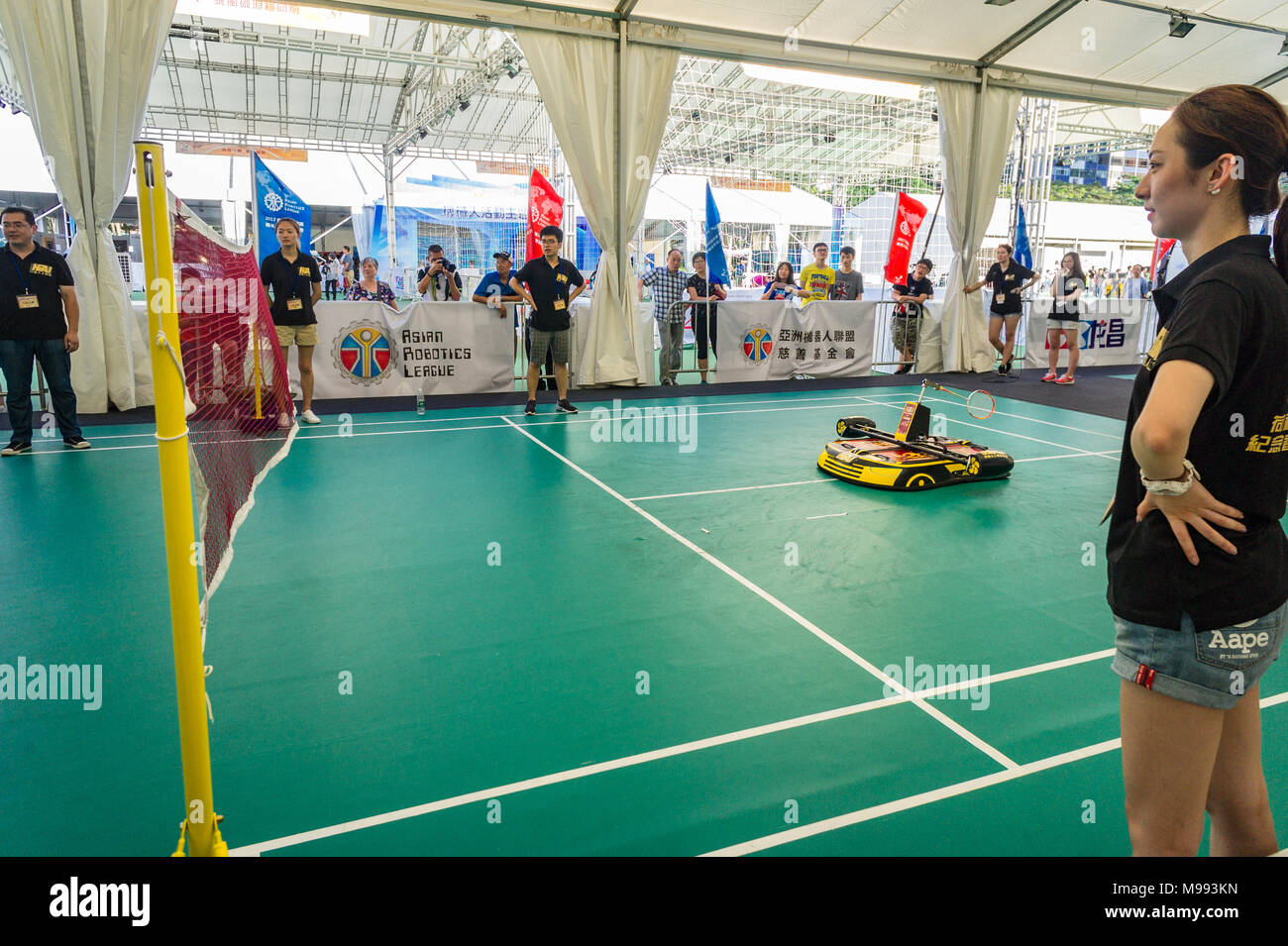 Robotic badminton player (machine) playing a game against human challengers as officials watch at a tech event in Hong Kong Stock Photo