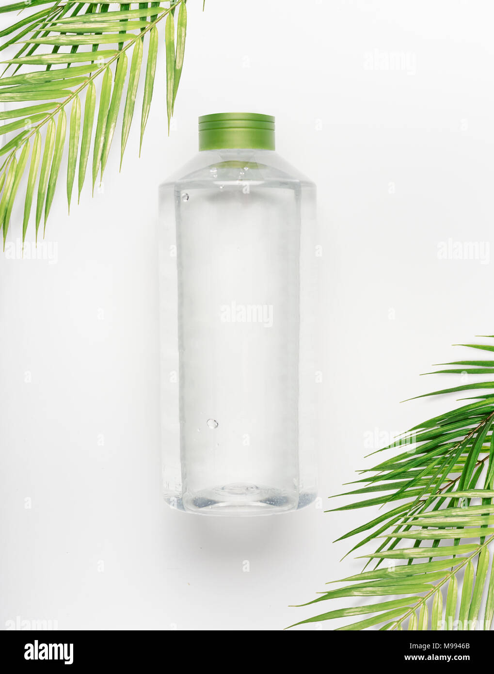 Transparent Liquid Bottle With Green Lid On White Desk Background