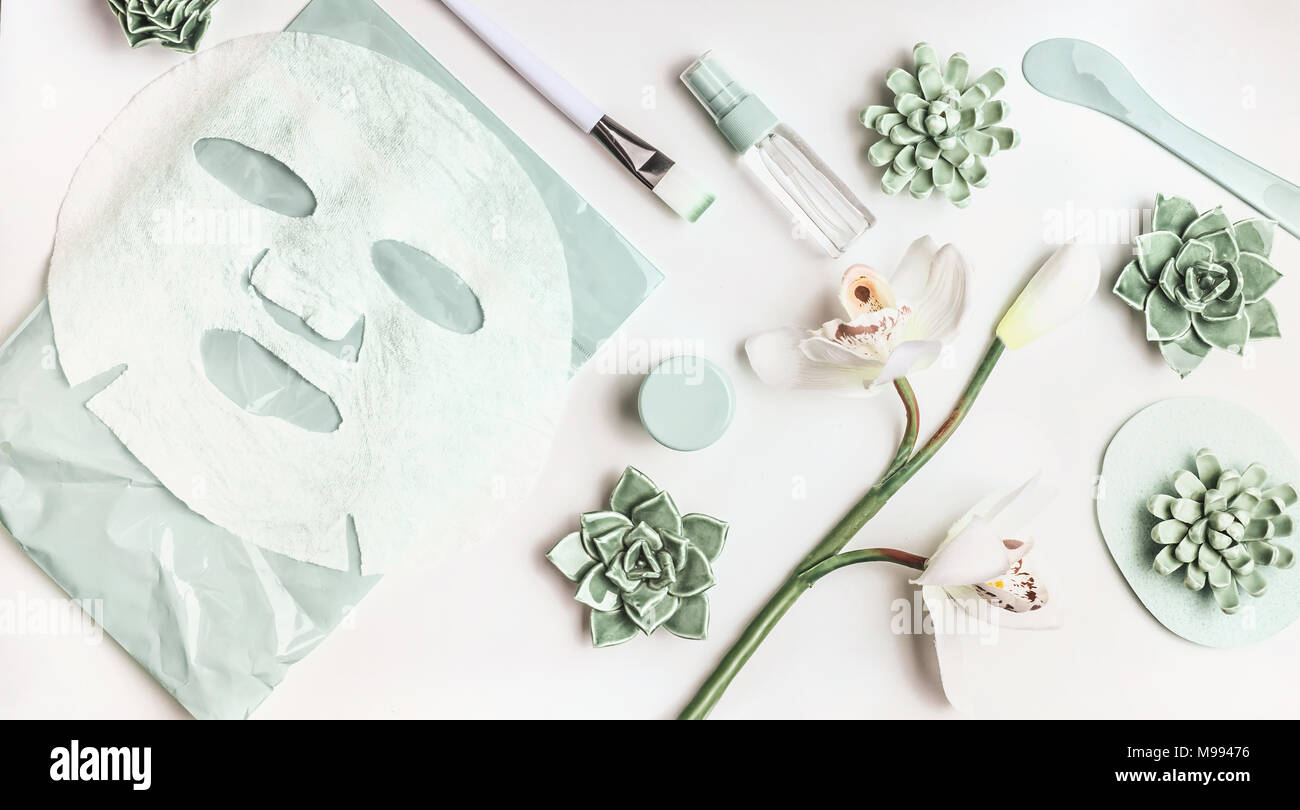 Skin care flat lay with facial sheet mask, mist spray bottle ...