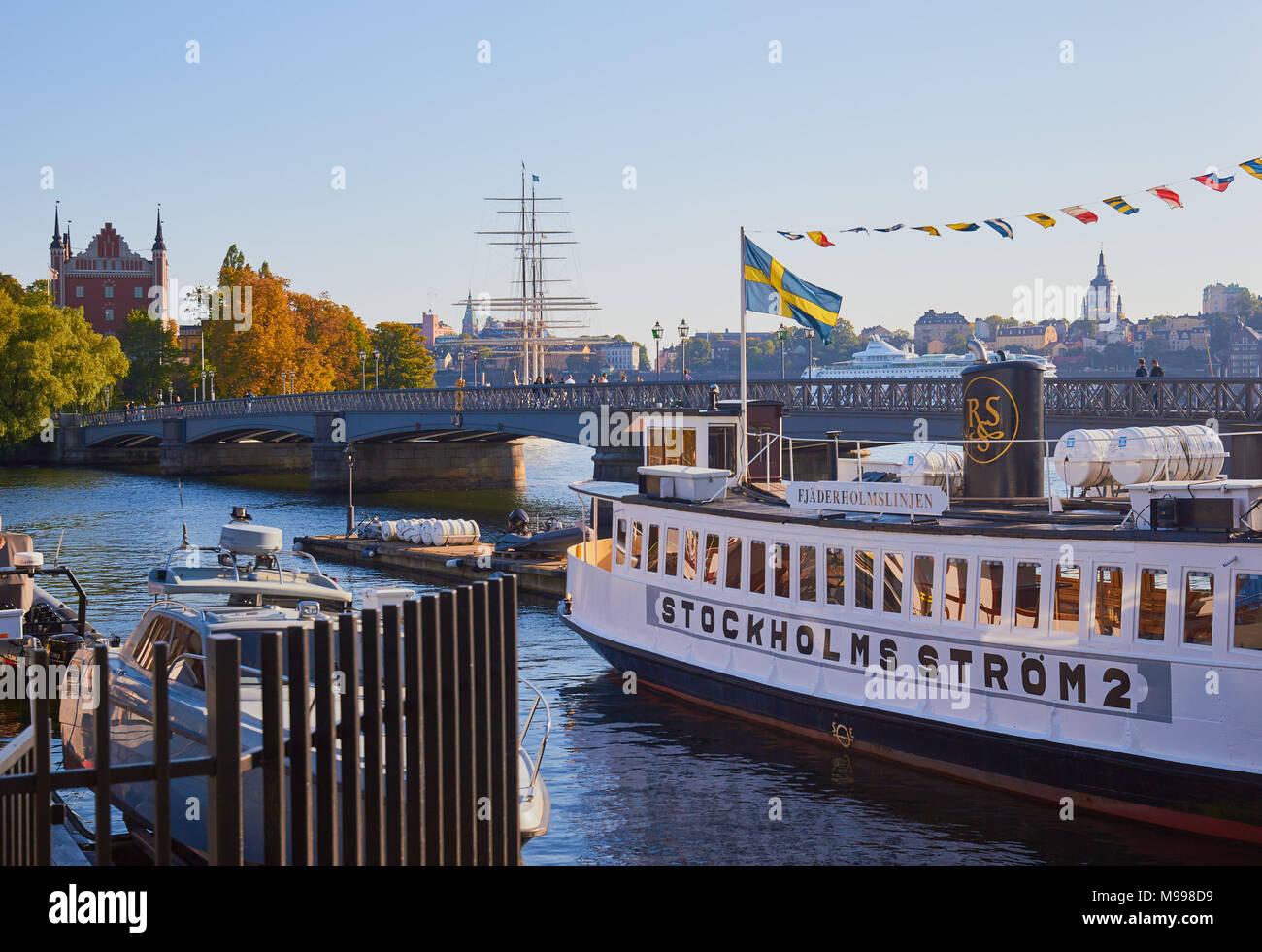 Sightseeing cruise boat with Swedish flag, Skeppsholmsbron Bridge, Stockholm, Sweden, Scandinavia Stock Photo