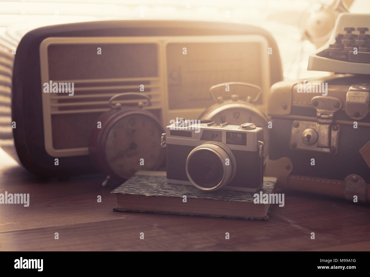 Vintage objects on a desk suitcase, camera, radio and alarm clocks Stock Photo Alamy
