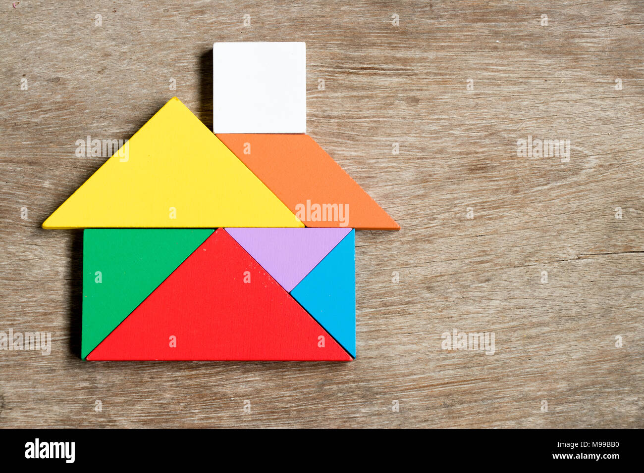 Color tangram puzzle in house shape on wood background Stock Photo - Alamy