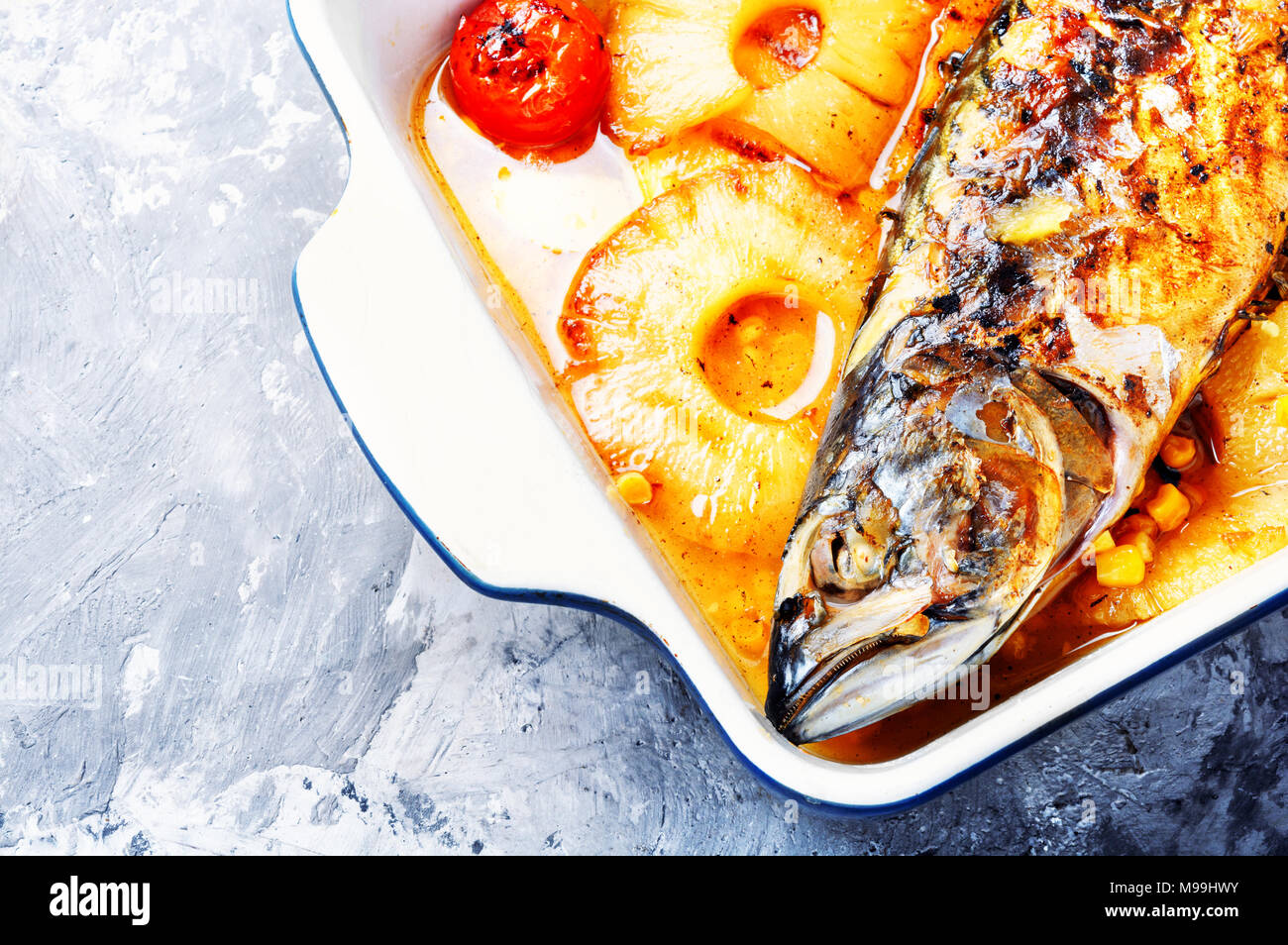 Baked fish with pineapple and mango in pan Stock Photo