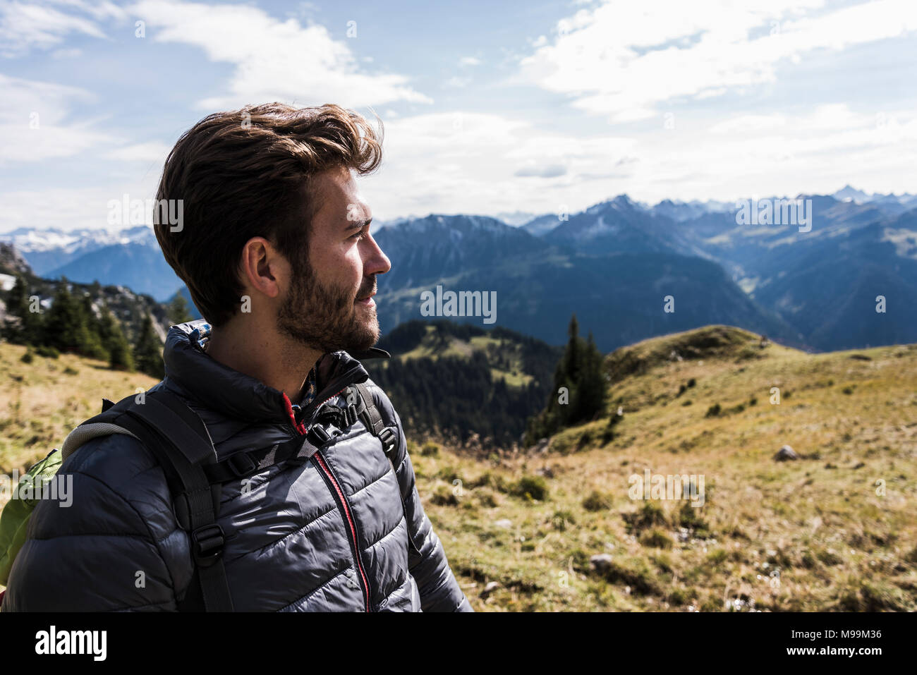 Austria, Tyrol, portrait of young man in mountainscape looking at view Stock Photo