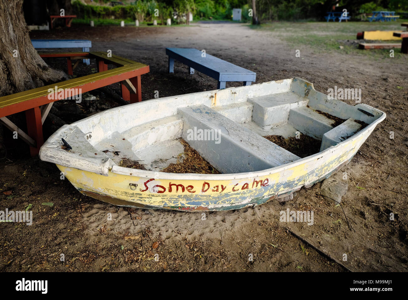 A white dingy rests on a beach under a tree on the island of St John in the US Virgin Islands. Stock Photo