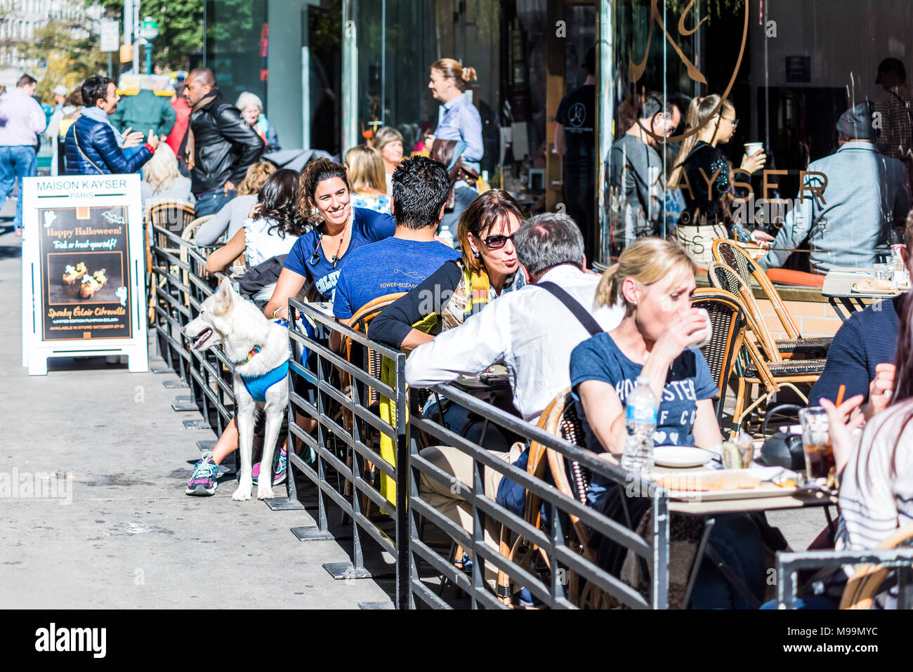 New York City, USA - October 28, 2017: Crowded restaurant outside on street with many people sitting outdoors, happy, smiling on sunny day in Midtown  Stock Photo