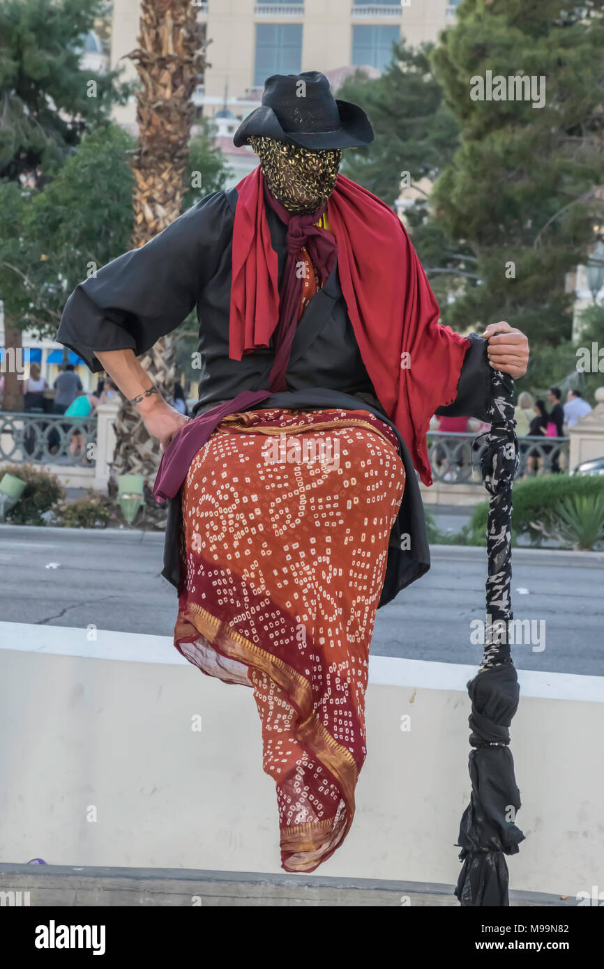 Las Vegas, Nevada / March 8, 2015: Street performer dressed in red and black appears to be levitating. Stock Photo