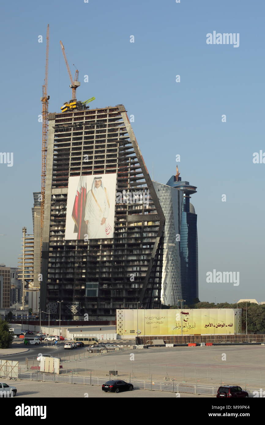 Doha, Qatar - March 21, 2018: skyscraper under construction in Qatar with a 12-storey high poster of Emir Tamim displayed on it. Stock Photo