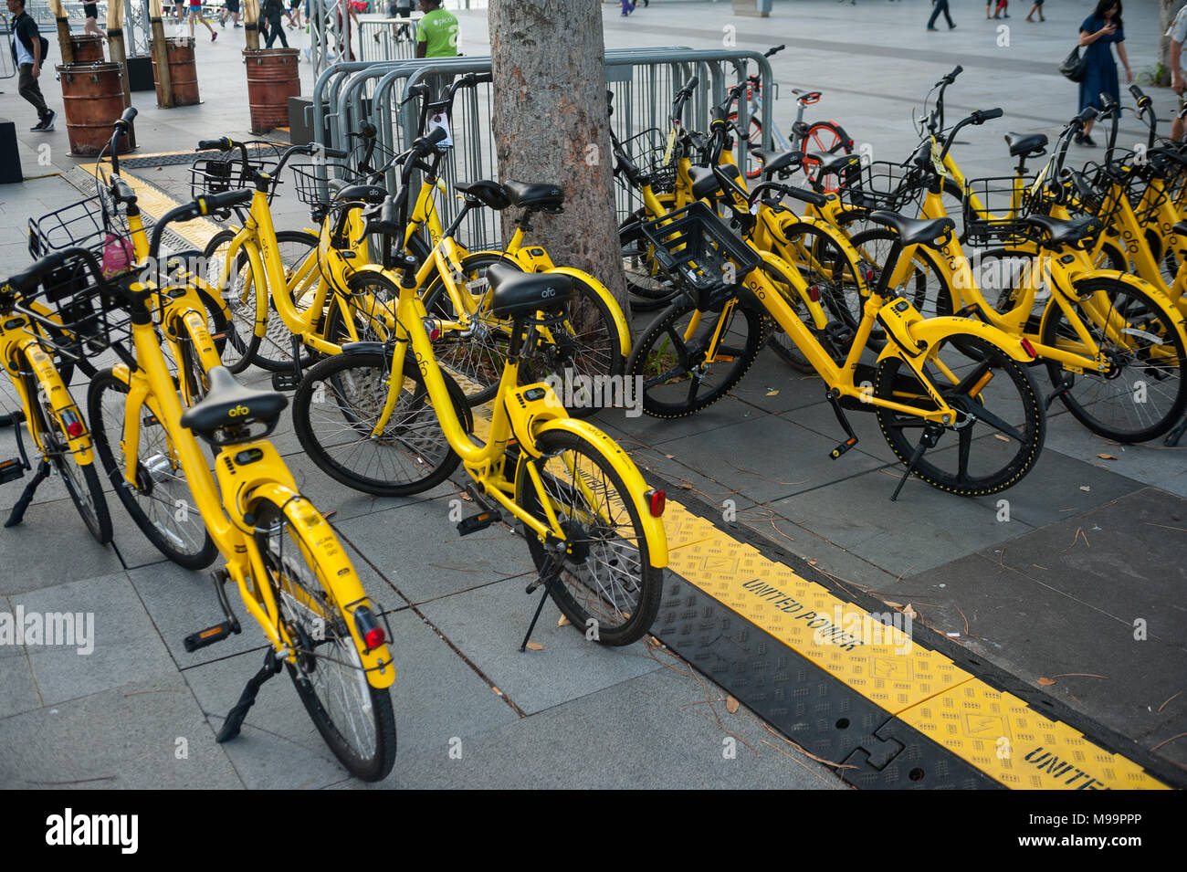 22.03.2018, Singapore, Republic of Singapore, Asia - Parked Ofo rental bikes in Marina Bay. The station-free rental bikes are distributed across town. Stock Photo