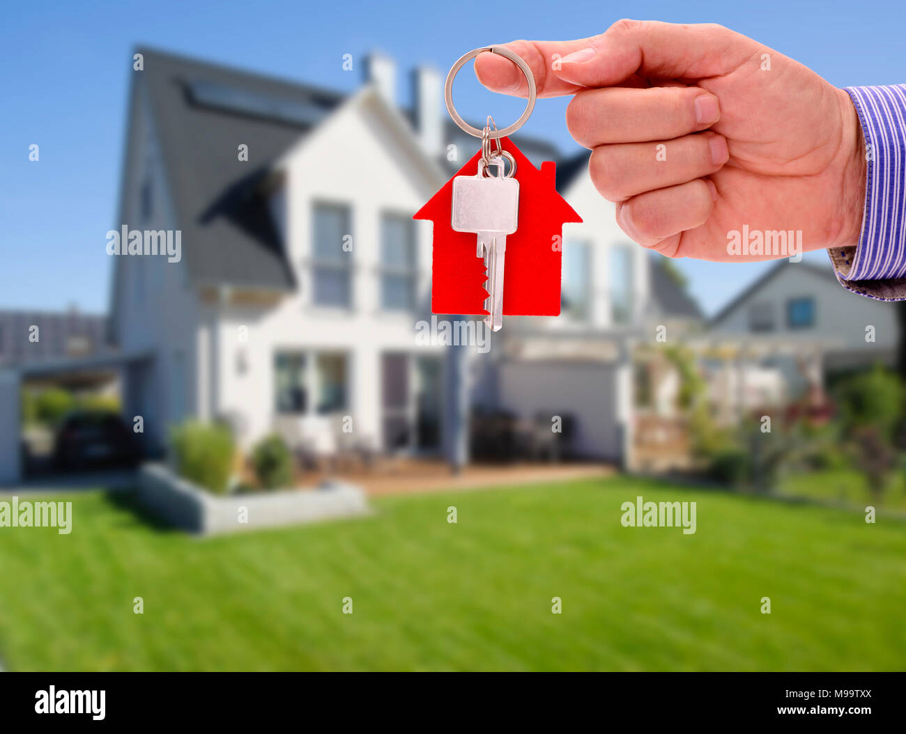 key in hand of real estate agent as offer for new residential home Stock Photo