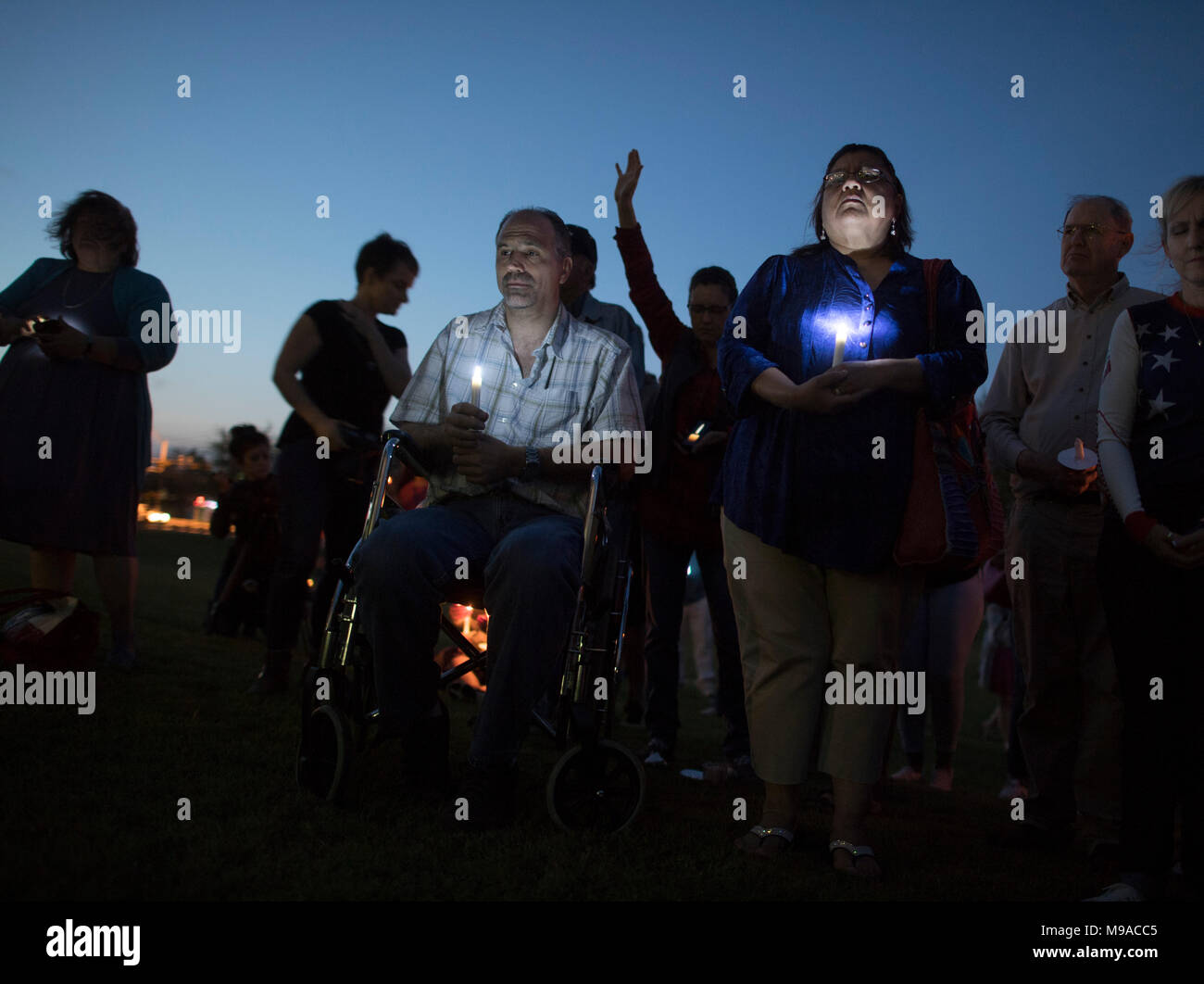 Mourners attend a candlelight vigil in Pflugerville, Texas, for the victims of recent Austin package bomb attacks, and to pray for the family of Mark A. Conditt, a resident accused of masterminding the attacks. Conditt killed himself on March 21 as police closed in on him. Stock Photo