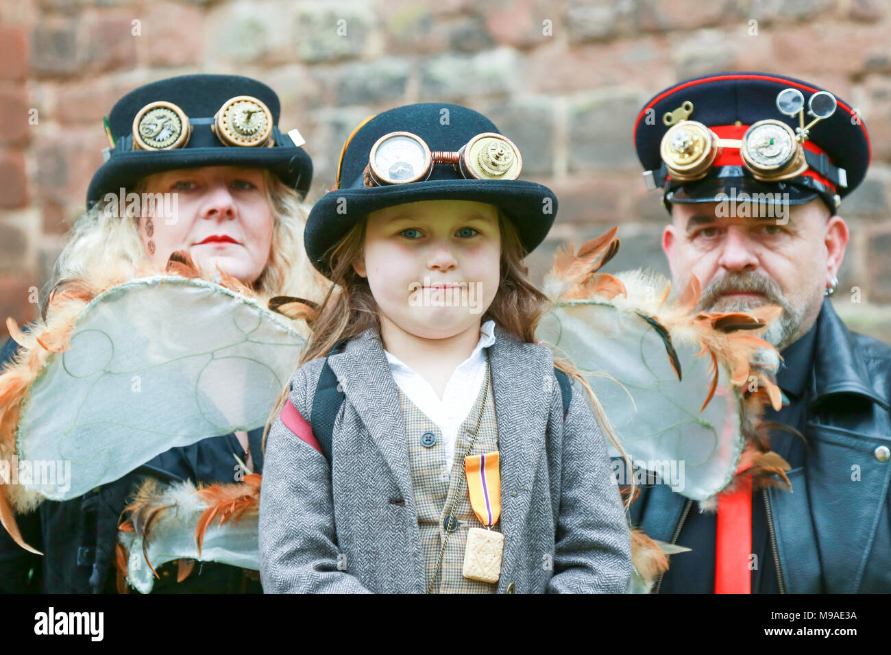 Young girl aged six 6 with her grandparents wearing steampunk clothing. Steampunk is a style of fashion that combines historical elements and anachronistic technology, often inspired by Edwardian science fiction. Stock Photo