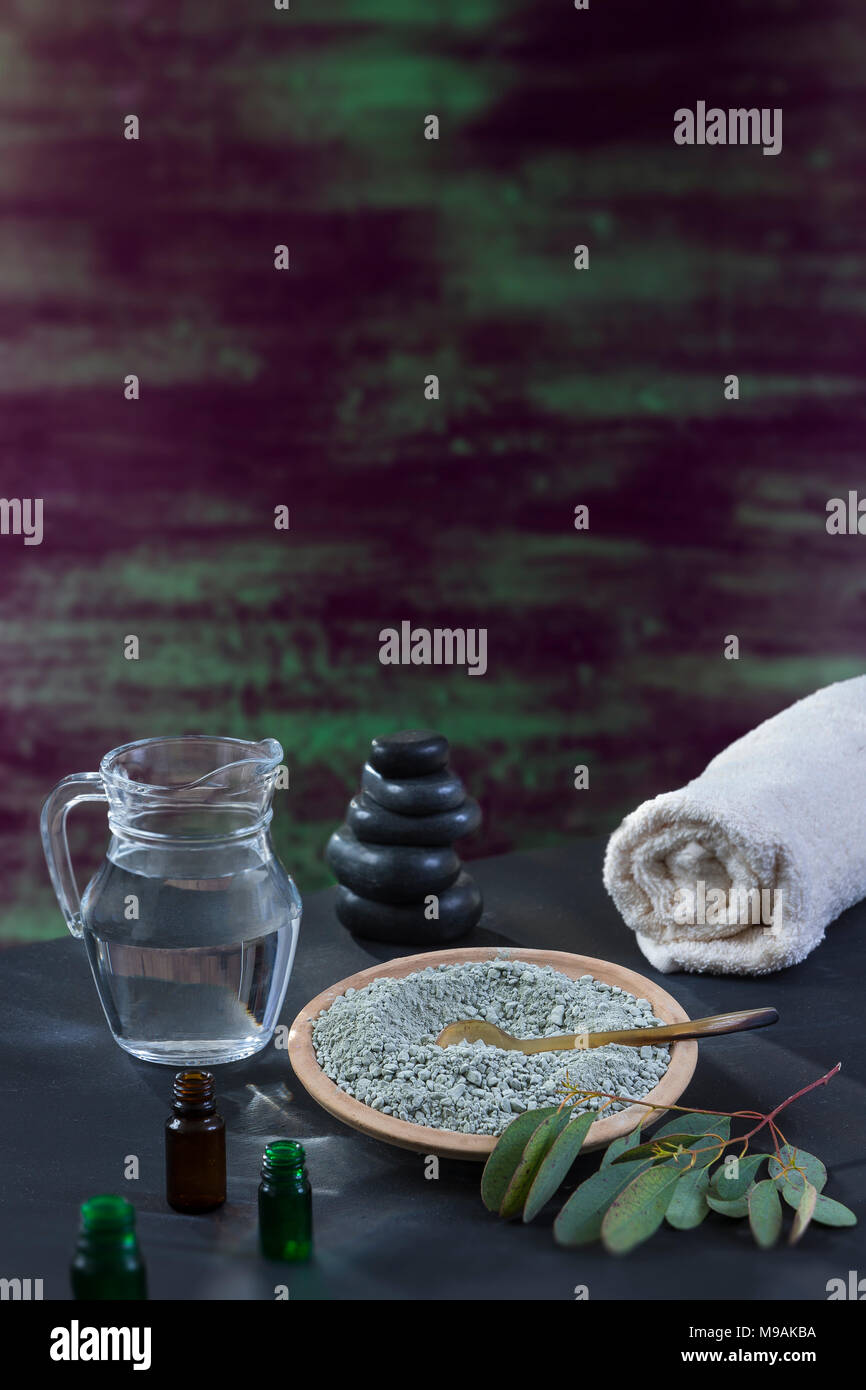 Beaty and Spa concept: glass mortar with eucaliptus leaf, essential oin, white towel cupp of clay on brushstrokes with thick paint in shades of green, blue, purple wooden texture Stock Photo
