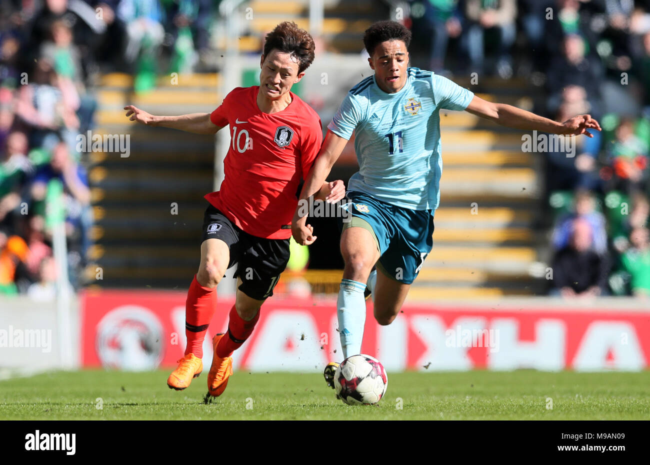 Northern Ireland's Jamal Lewis (right) and South Korea's Jae-Sung Lee battle for the ball during the international friendly match at Windsor Park, Belfast. Stock Photo