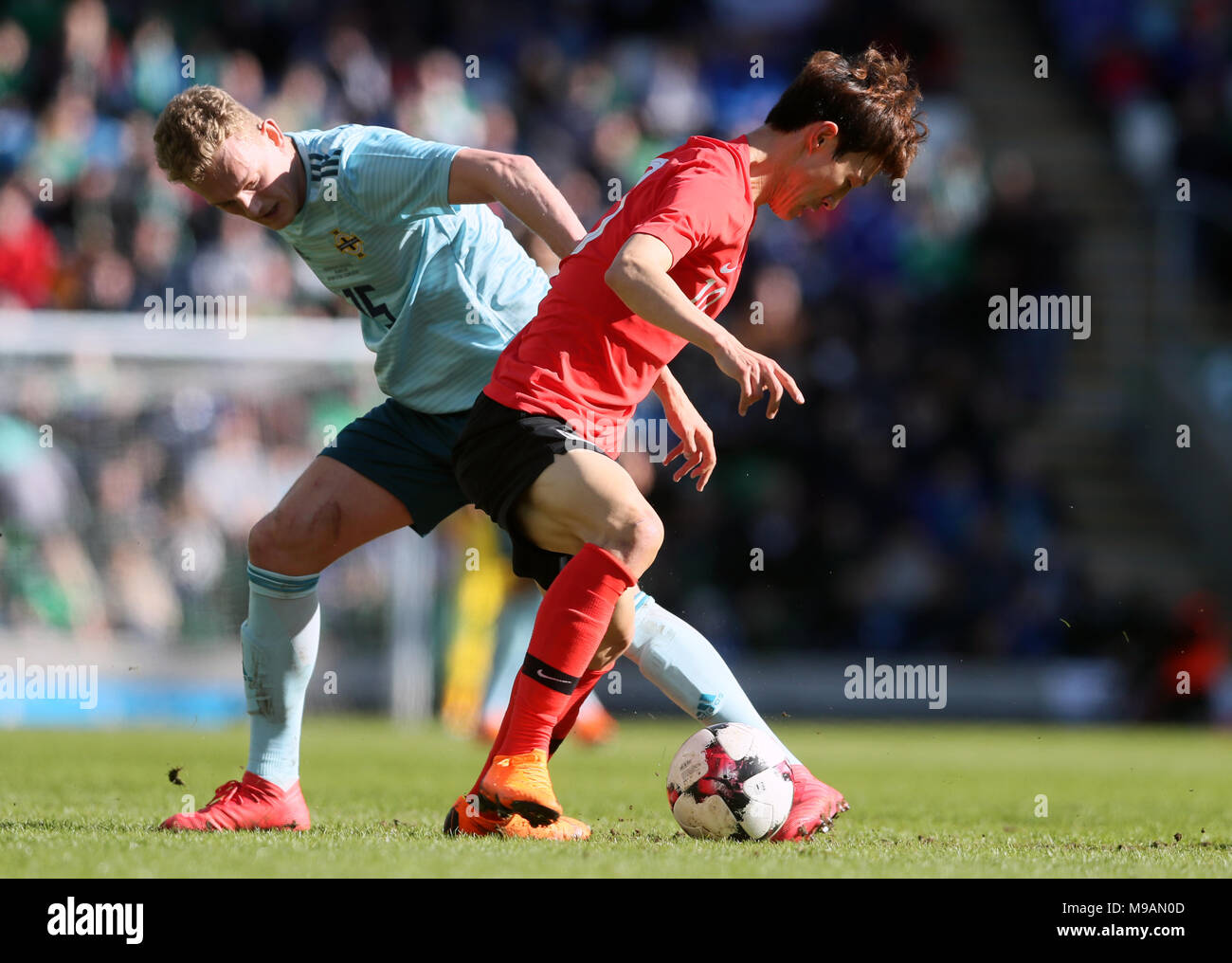 Northern Ireland's George Saville (left) and South Korea's Jae-Sung Lee battle for the ball during the international friendly match at Windsor Park, Belfast. Stock Photo