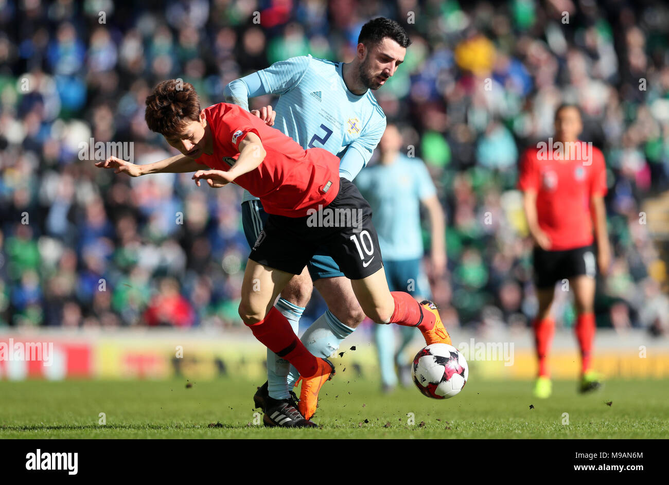 Northern Ireland's Conor McLaughlin (right) and South Korea's Jae-Sung Lee battle for the ball during the international friendly match at Windsor Park, Belfast. Stock Photo