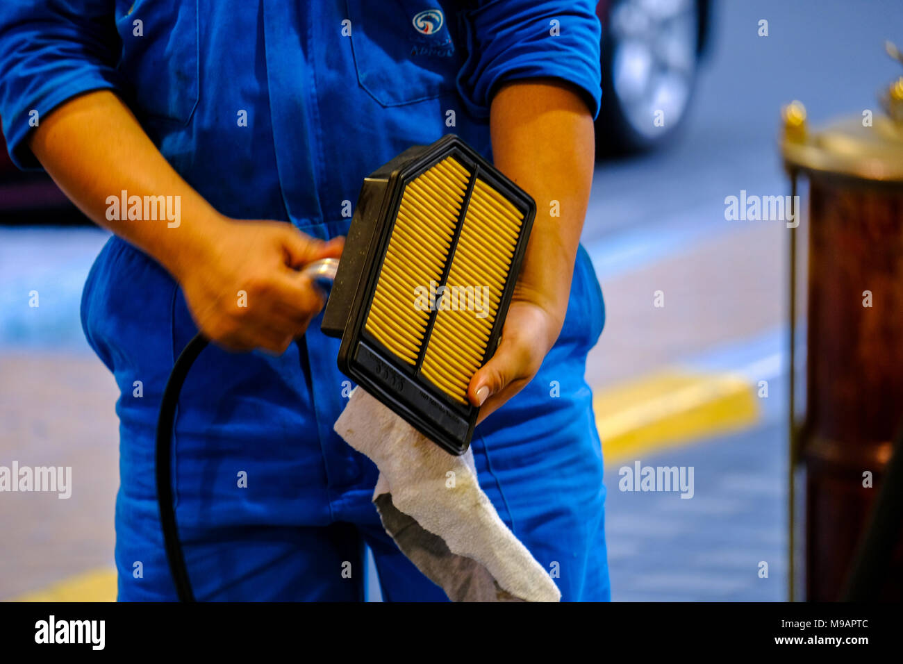 ADNOC employee at ADNOC Petrol Station Cleaning Engine Filter with air