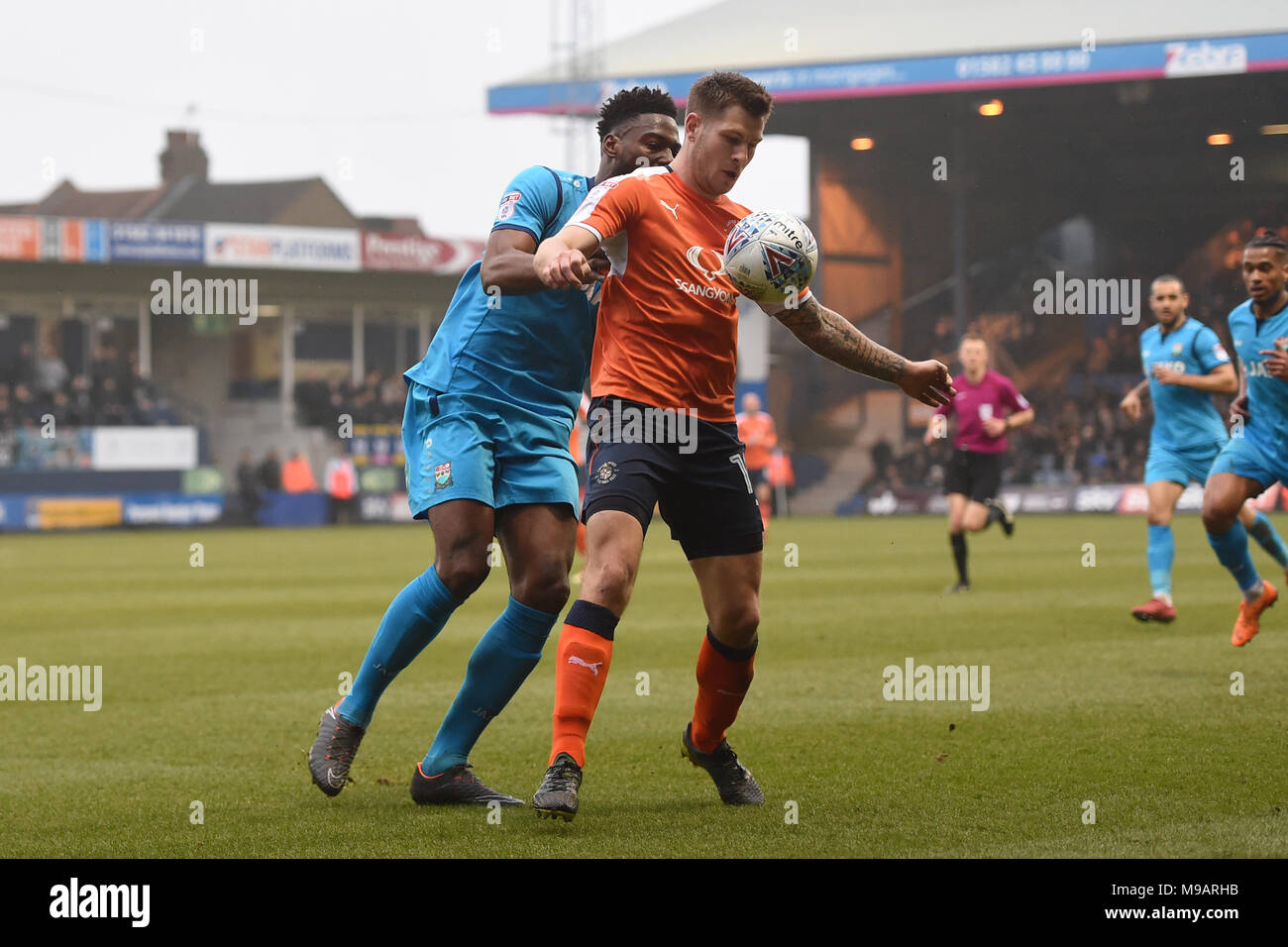 Luton Town's James Collins shields the ball from Barnet's Ricardo Almeida Santos during the Sky Bet League Two match at Kenilworth Road, Luton. Stock Photo