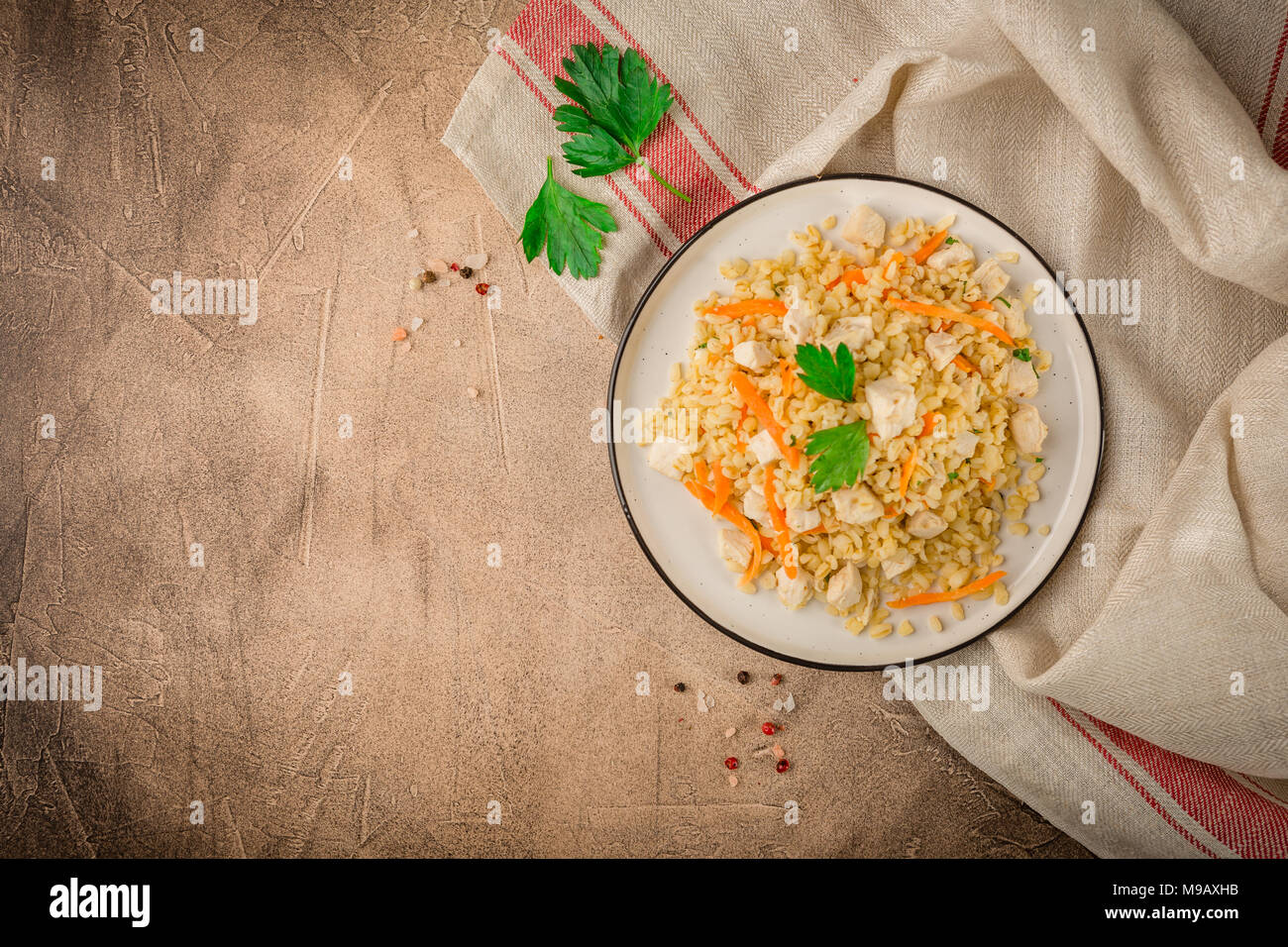 Bulgur Pilaf with chicken on brown background concrete. Top view, place for text Stock Photo Alamy