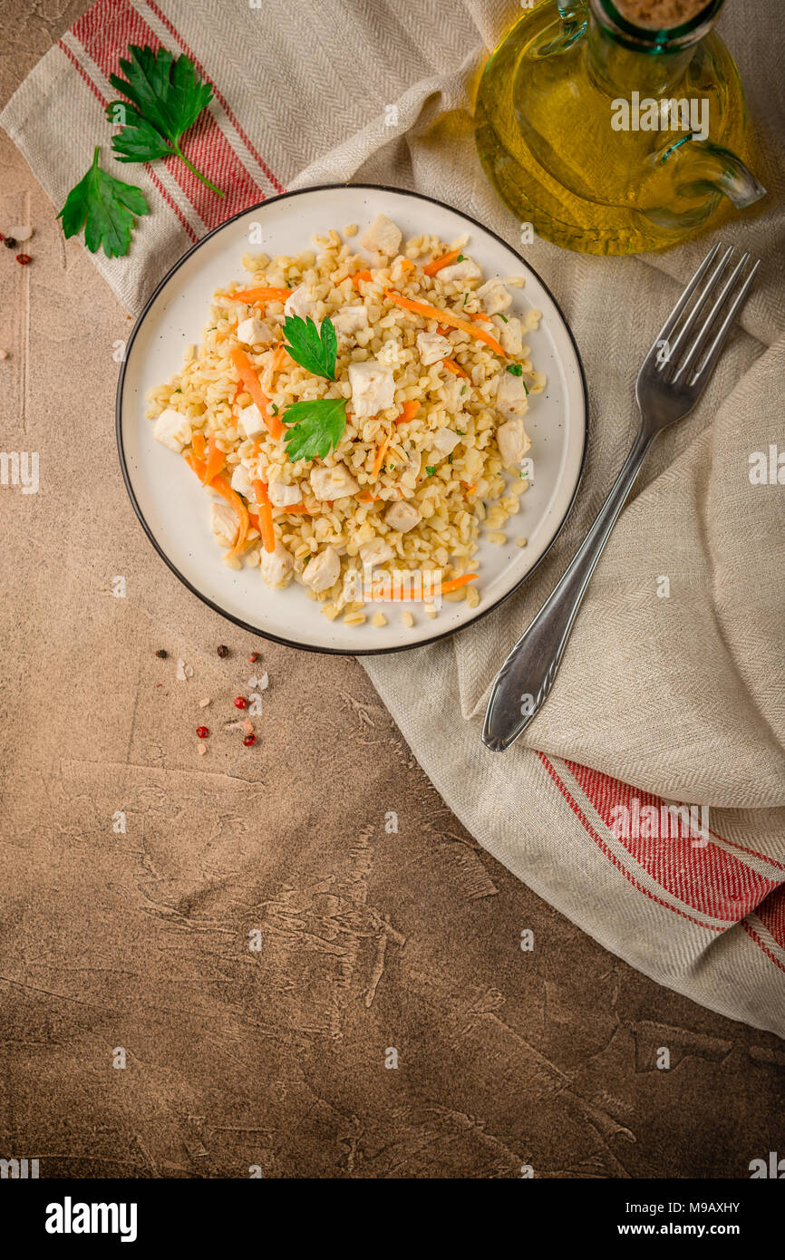 Bulgur Pilaf with chicken on brown background concrete. Top view, place for text Stock Photo Alamy