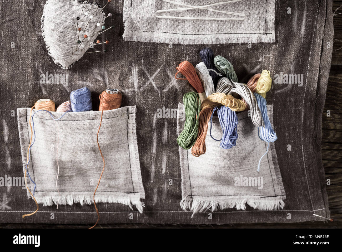 Needles and colored threads in the mat tailor pocket Stock Photo