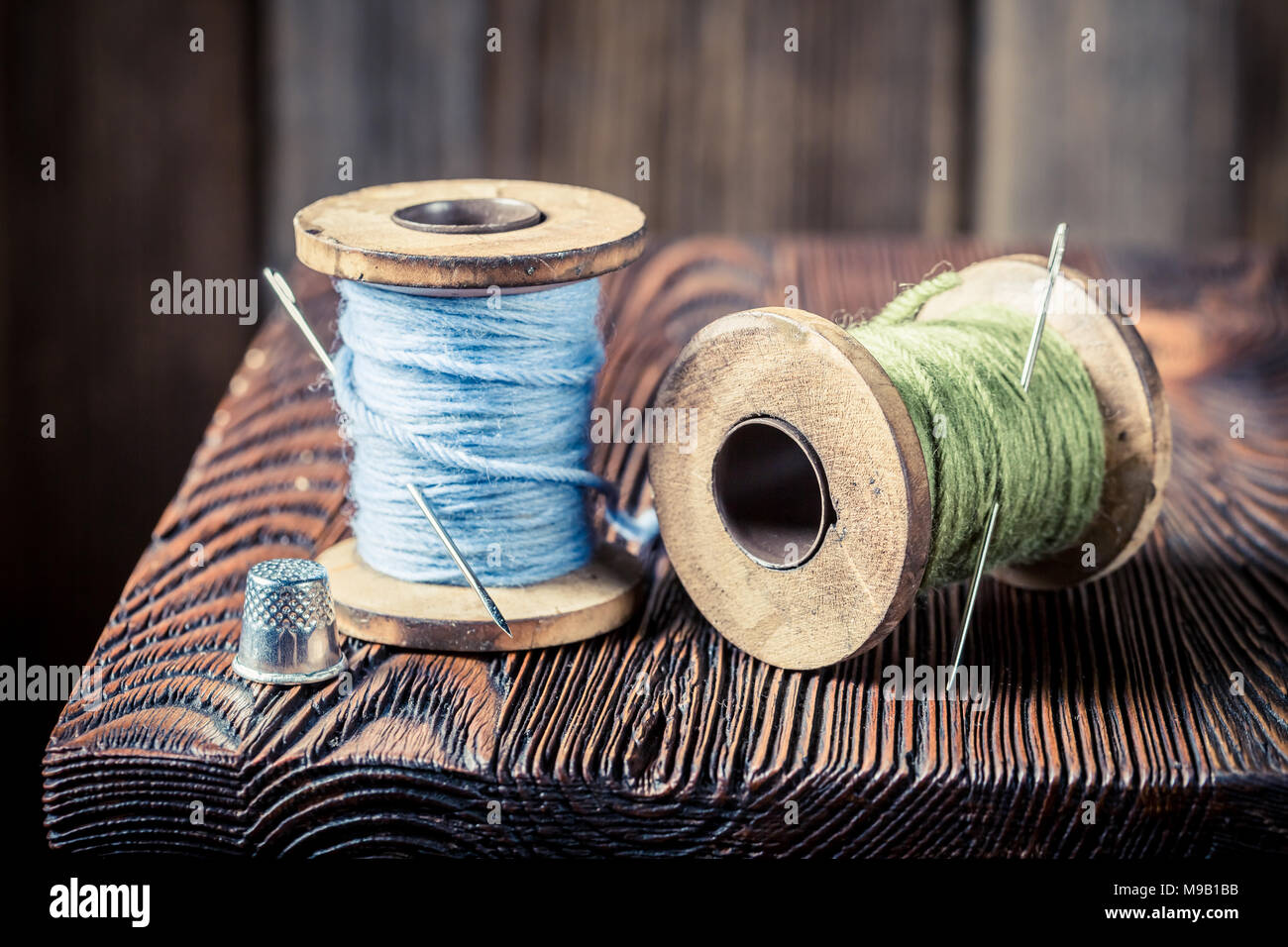 Closeup of vintage needle and threads on wooden box Stock Photo