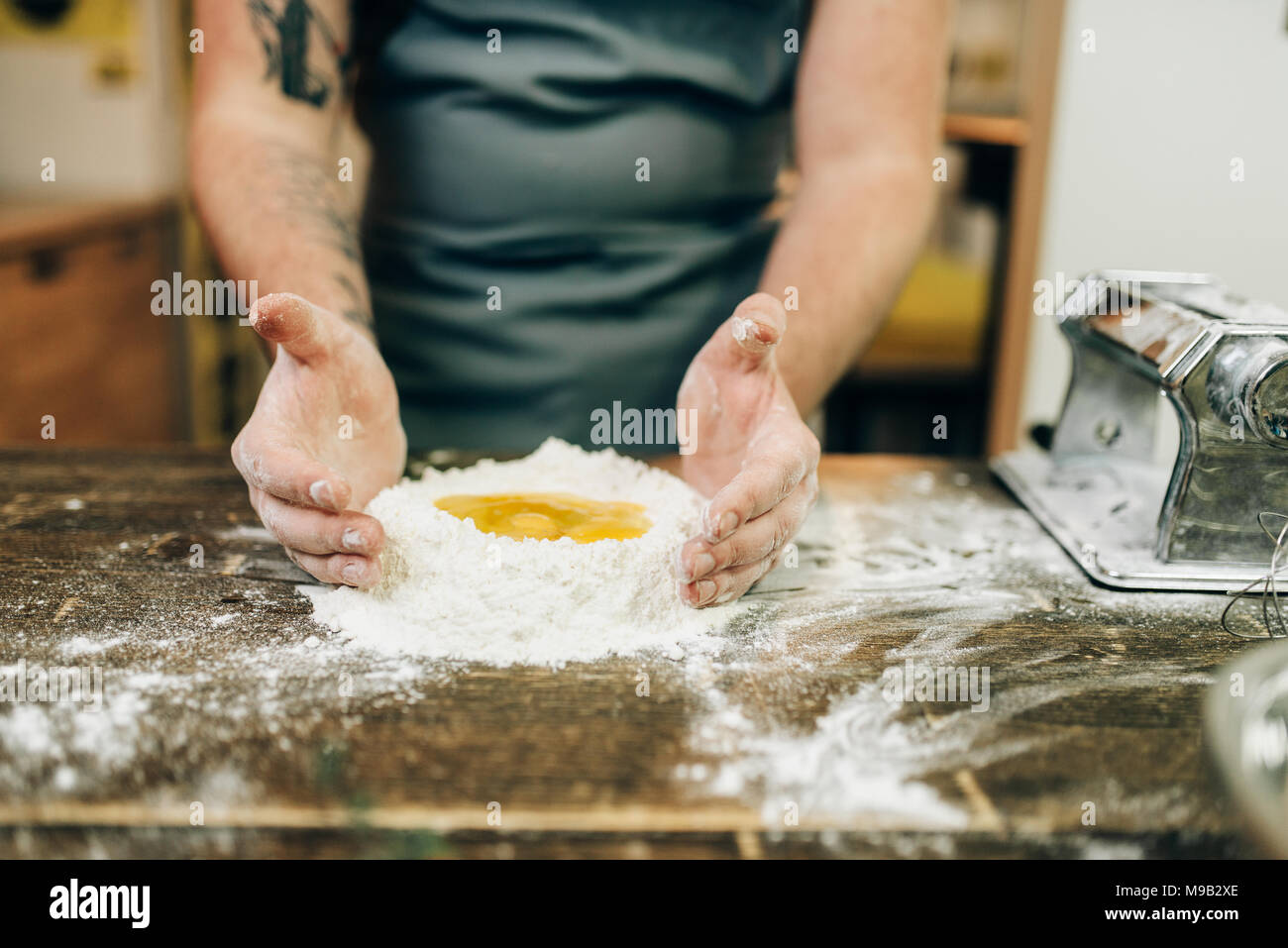 Pasta cooking, bearded chef preparing dough Stock Photo