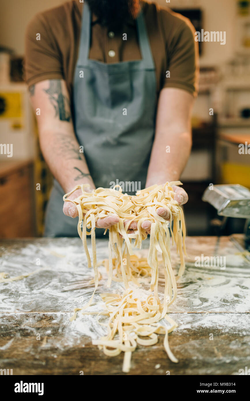 Male chef hands with uncooked homemade pasta Stock Photo - Alamy