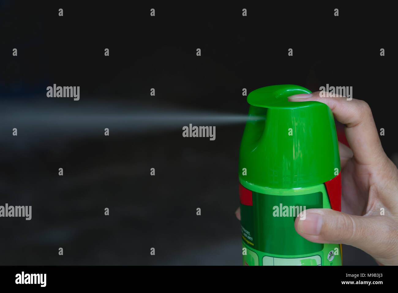 Hand holding mosquito spray. Human using mosquito spray from bottle