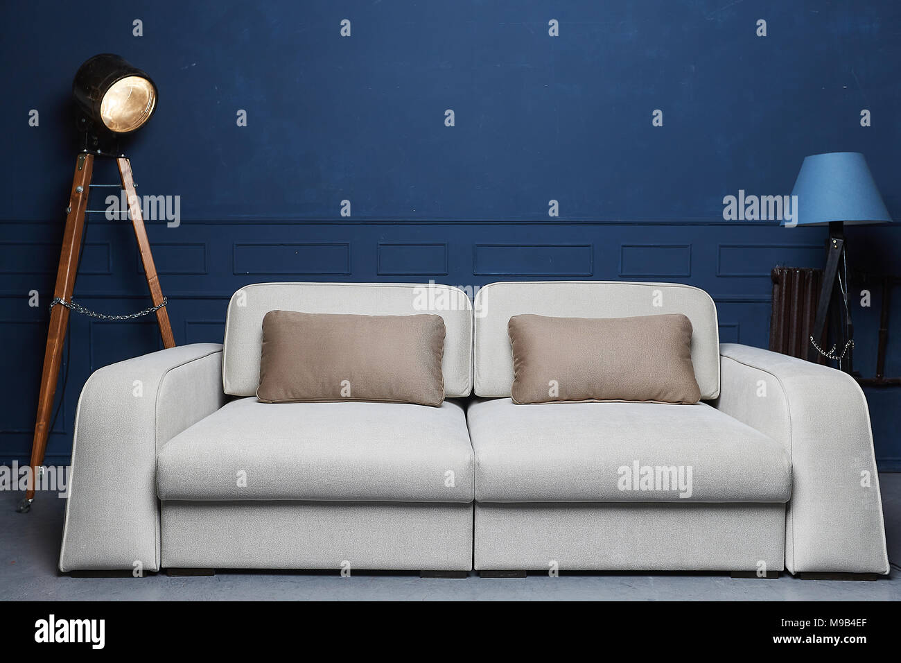 Beige Sofa In A Dark Blue Interior With A Lamp And A Studio