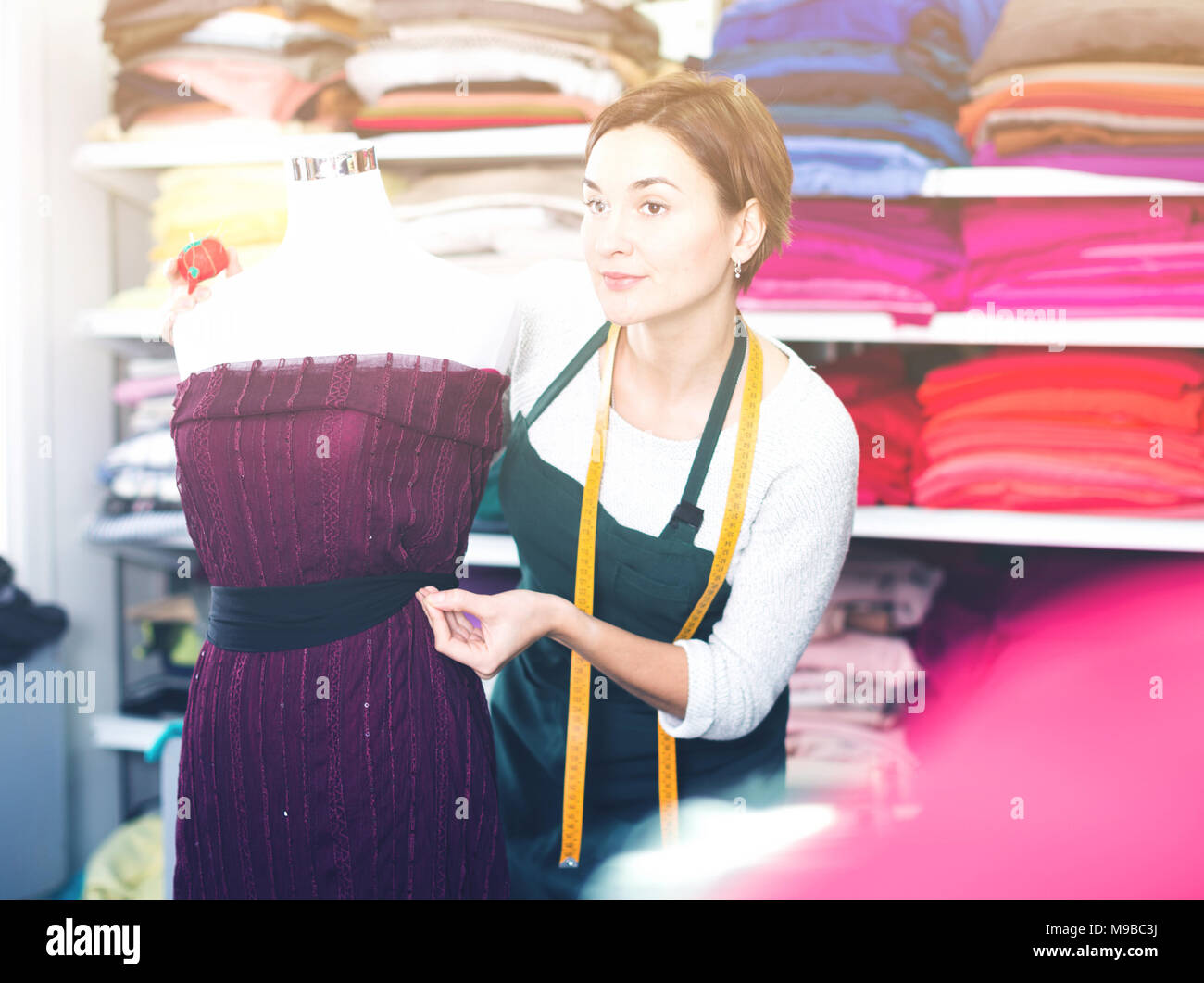 Female tailor finishing work at festive dress at studio Stock Photo - Alamy