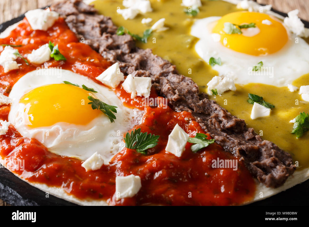 huevos divorciados, fried eggs on corn tortillas with two salsas macro, mexican breakfast Stock Photo