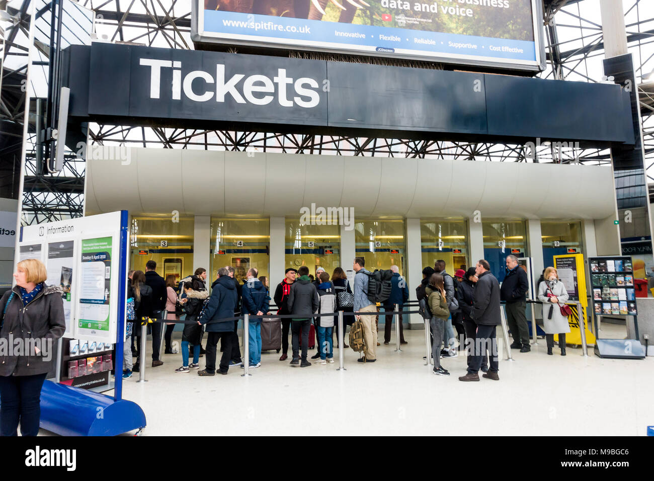 People queue to buy tickets at the ticket office at Reading Railway station in the UK. Stock Photo