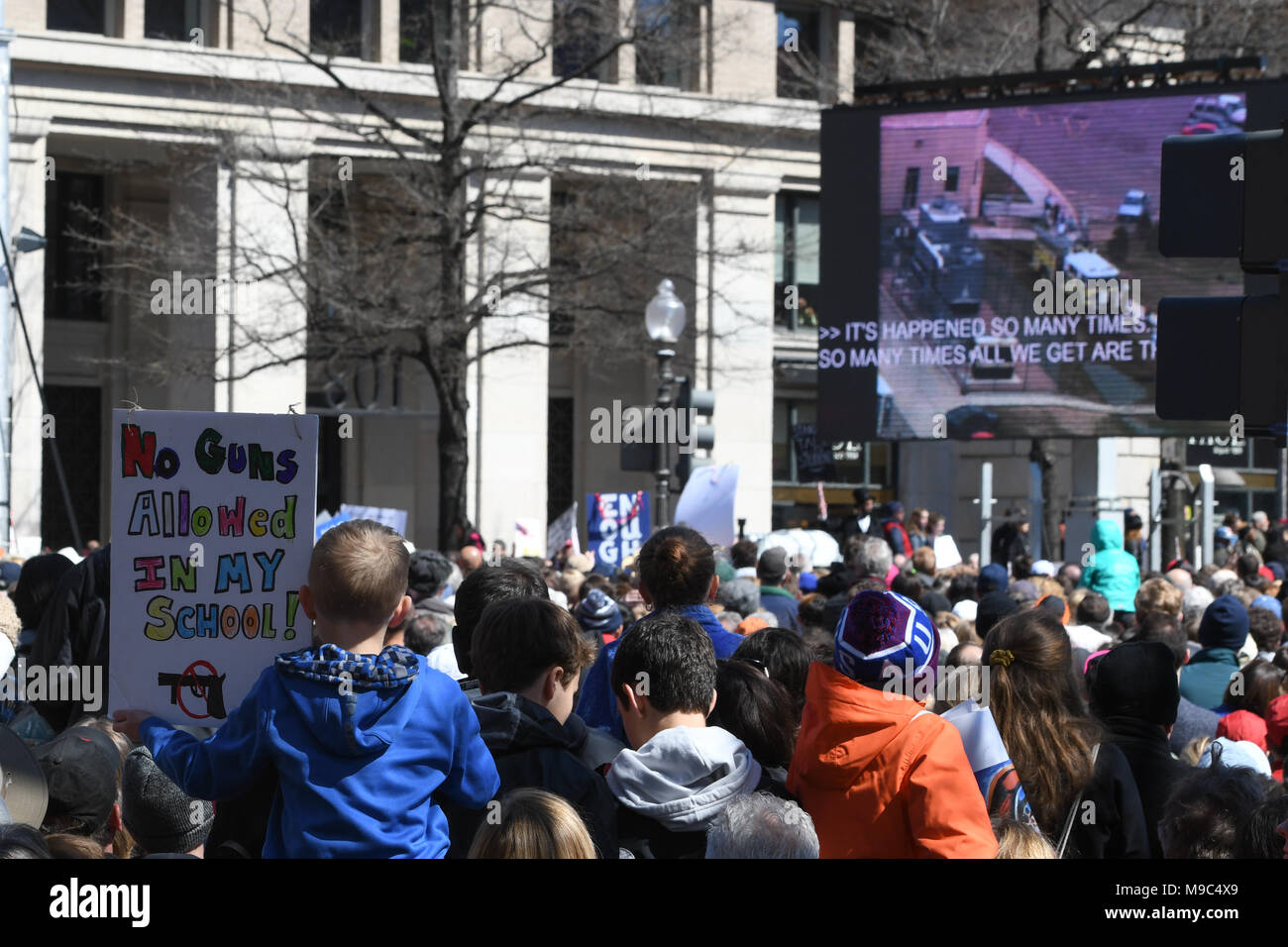 Washington, DC, USA. 24th Mar, 2018. A young man holds a sign saying no guns allowed in his school while he watches the monitor during the March for your Lives protest and march for gun control in the United States, held on Pennsylvania Avenue in Washington, DC. Credit: csm/Alamy Live News Stock Photo