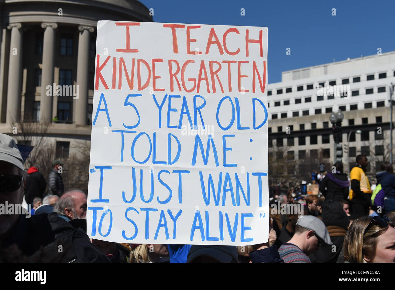 Washington, DC, USA. 24th Mar, 2018. A teacher protesting holds up a sign asking to protect children during the March for your Lives protest and march for gun control in the United States, held on Pennsylvania Avenue in Washington, DC. Credit: csm/Alamy Live News Stock Photo