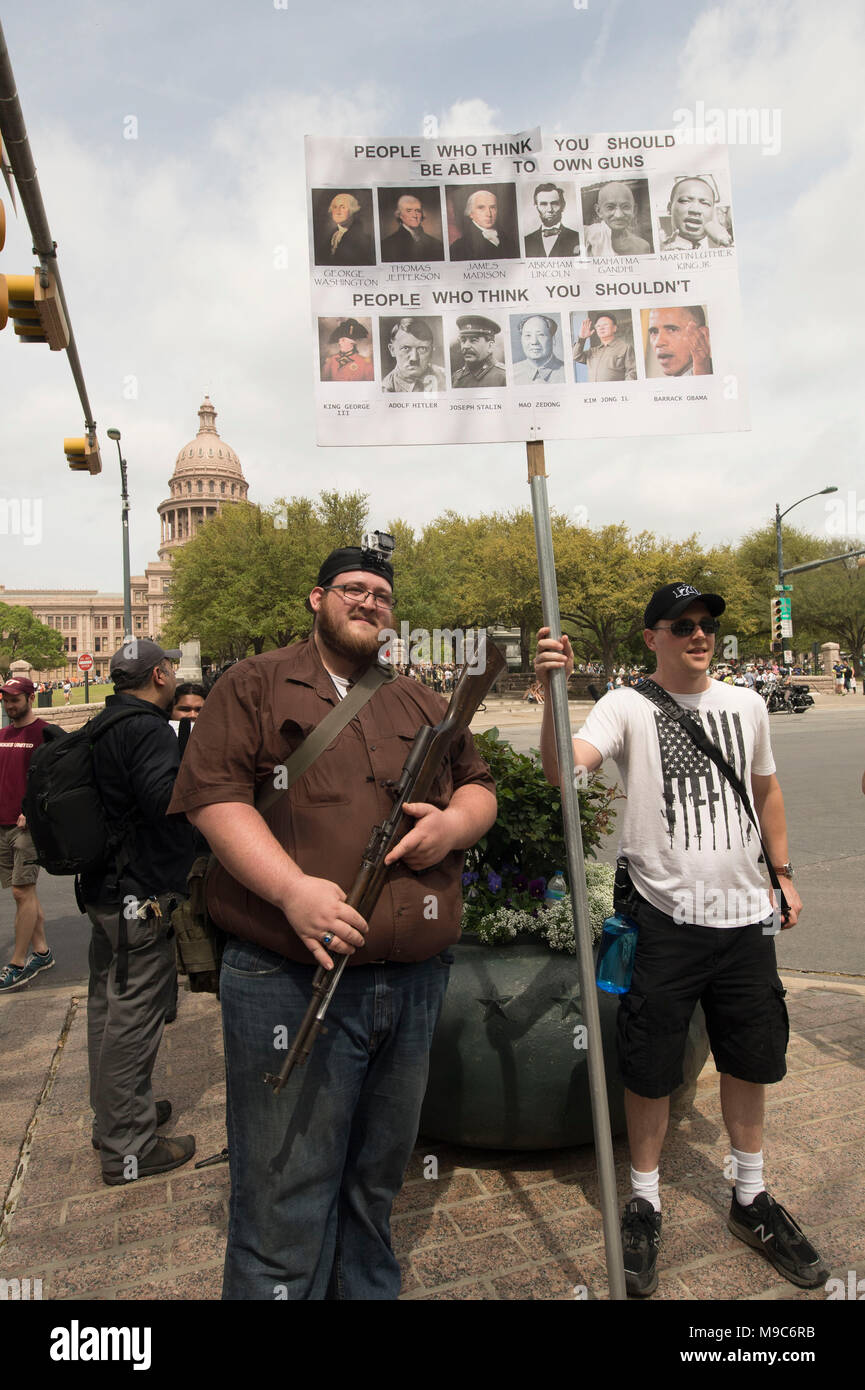 Gun rights supporters carrying long guns stand in the midst of nearly 10,000 marchers protesting gun violence at the March For Our Lives event in Austin Texas near the State Capitol building. Stock Photo