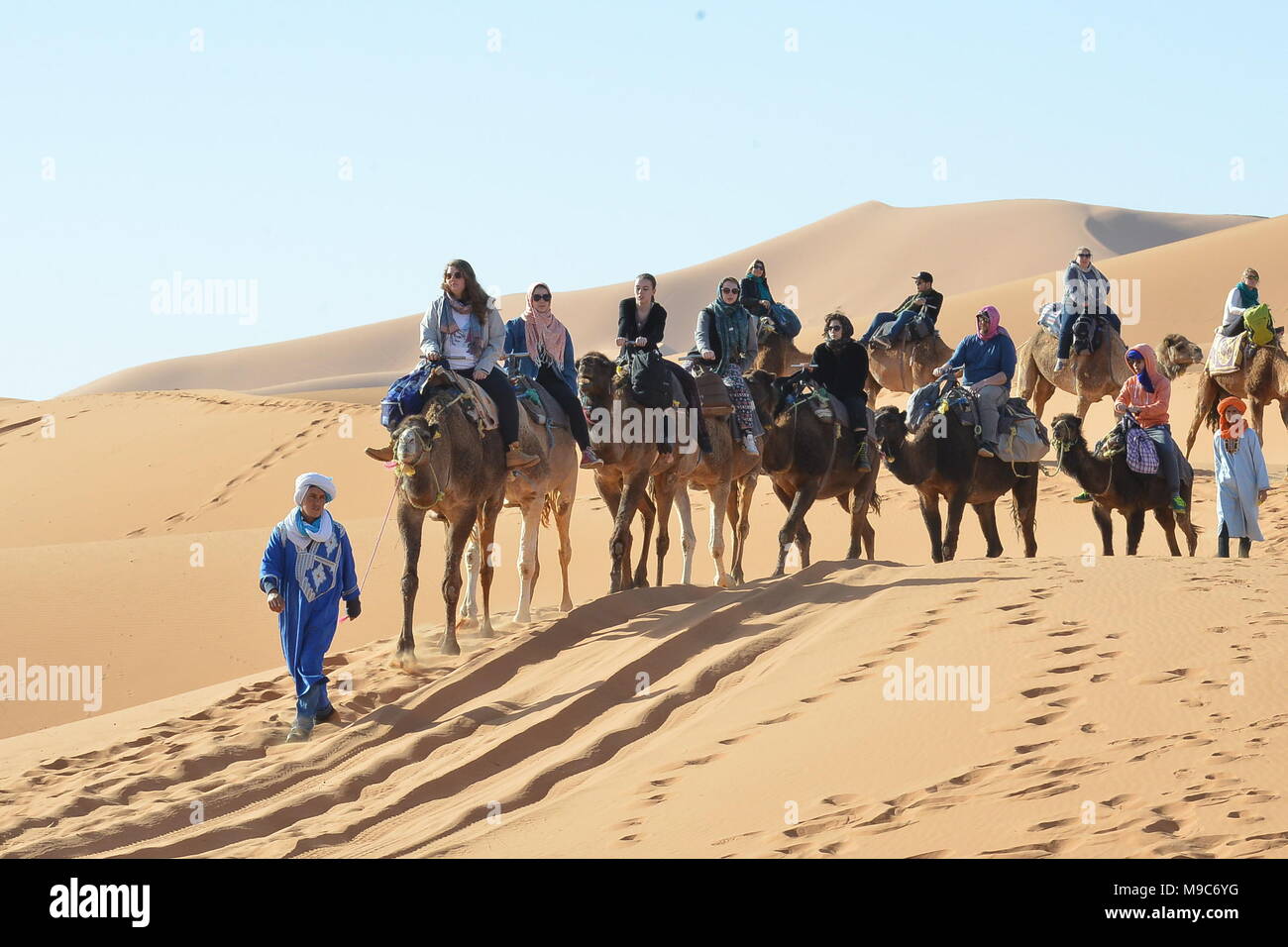 Merzouga, Morocco. 24th Mar, 2018. People ride camels in Merzouga, Morocco, on March 24, 2018. Tourists came to visit the small village of Merzouga for its proximity to Erg Chebbi, a Saharan erg. Credit: Aissa/Xinhua/Alamy Live News Stock Photo