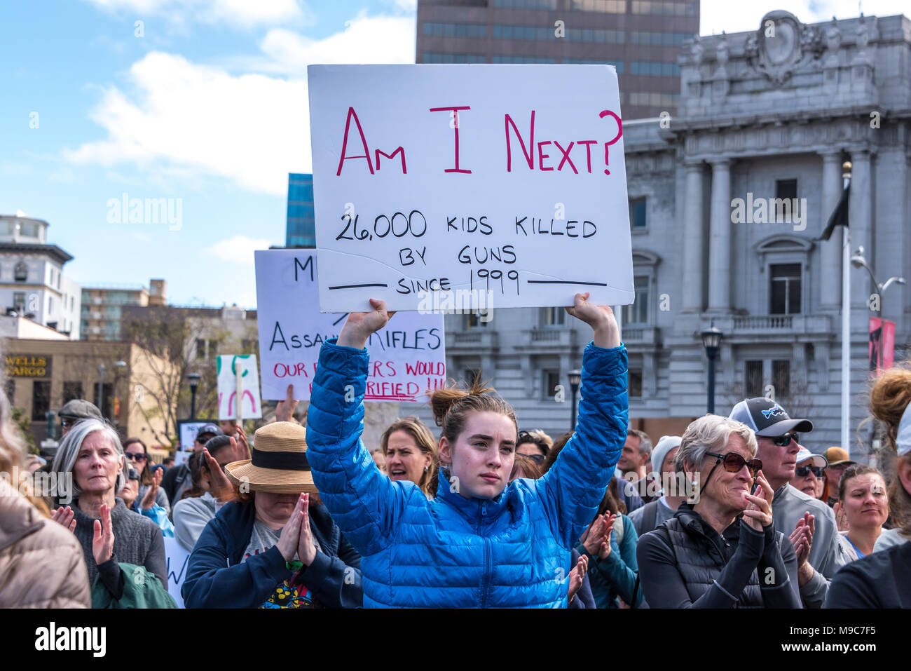 San Francisco, USA. 24th March, 2018. At the March for Our Lives rally and march to call for gun control and end gun violence, a young woman teenage student holds a sign reading, 'Am I next?' with the statistic of 26,000 kids killed by guns since 1999. Shelly Rivoli/Alamy Live News Stock Photo