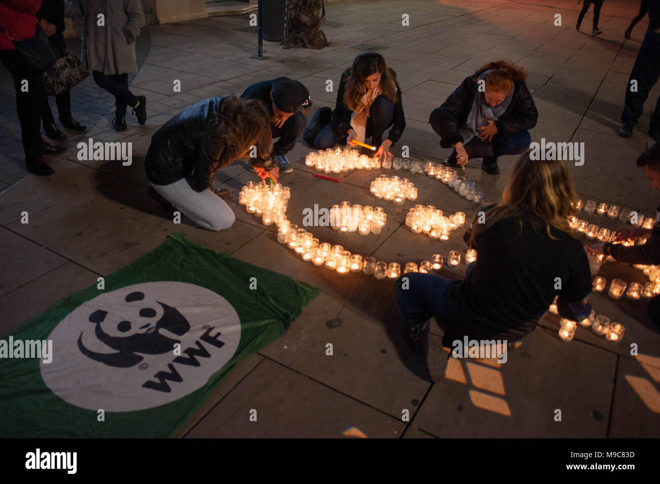 Malaga, Spain. 24th Mar, 2018. Members from the World Wildlife Fund (WWF) seen lighting candles during the Earth Hour in downtown Malaga. The figure with candles depicts a panda, the symbol of WWF.Thousands of cities across the world turned off electric lights to warn of the climate change dangers during the ''˜Earth Hourâ Credit: Jesus Merida/SOPA Images/ZUMA Wire/Alamy Live News Stock Photo