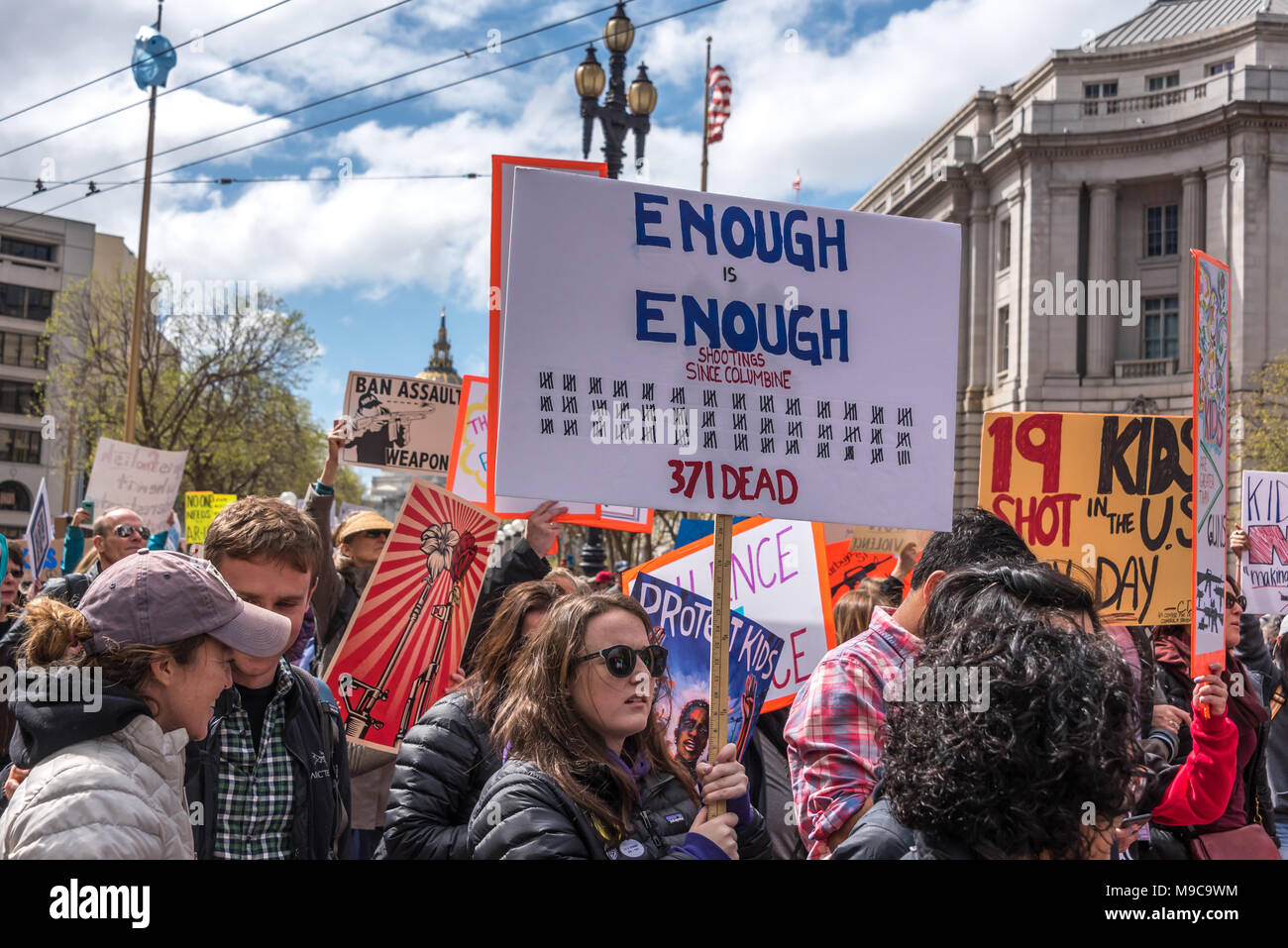 San Francisco, USA. 24th March, 2018. March for Our Lives rally and march to call for gun control and end gun violence; people march down Market Street with signs, one sign reads 'Enough is enough' with tallies for the number of deaths from shootings since Columbine (371). Shelly Rivoli/Alamy Live News Stock Photo