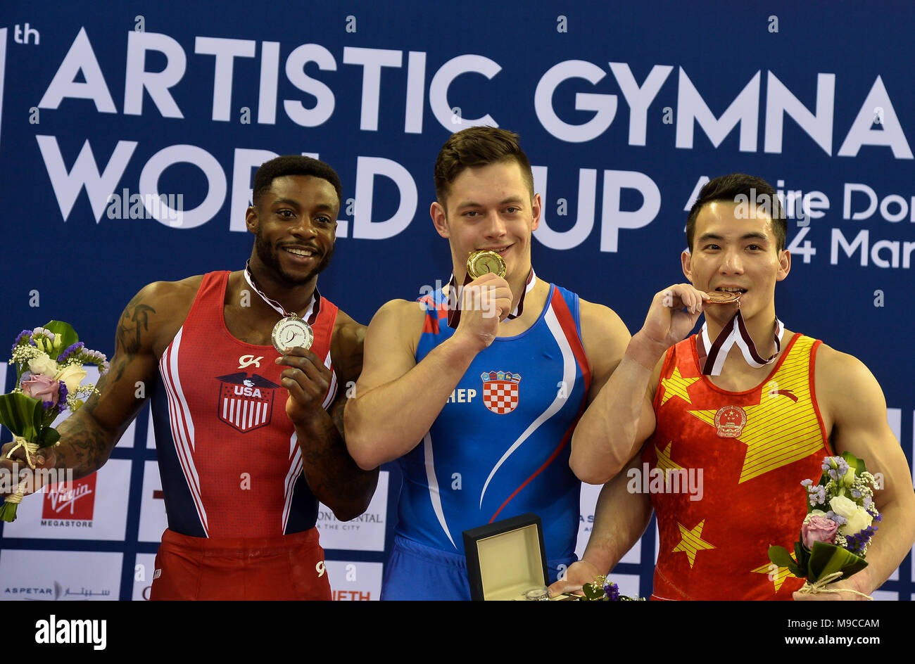 Doha, Capital of Qatar. 24th Mar, 2018. Gold medalist Tin Srbic (C) of Croatia, silver medalist Marvin Kimble (L) of the United States and bronze medalist Deng Shudi of China pose during the awarding ceremony for the Men's Horizontal Bar final at the 11th FIG Artistic Gymnastics Individual Apparatus World Cup in Doha, Capital of Qatar, on March 24, 2018. Credit: Nikku/Xinhua/Alamy Live News Stock Photo