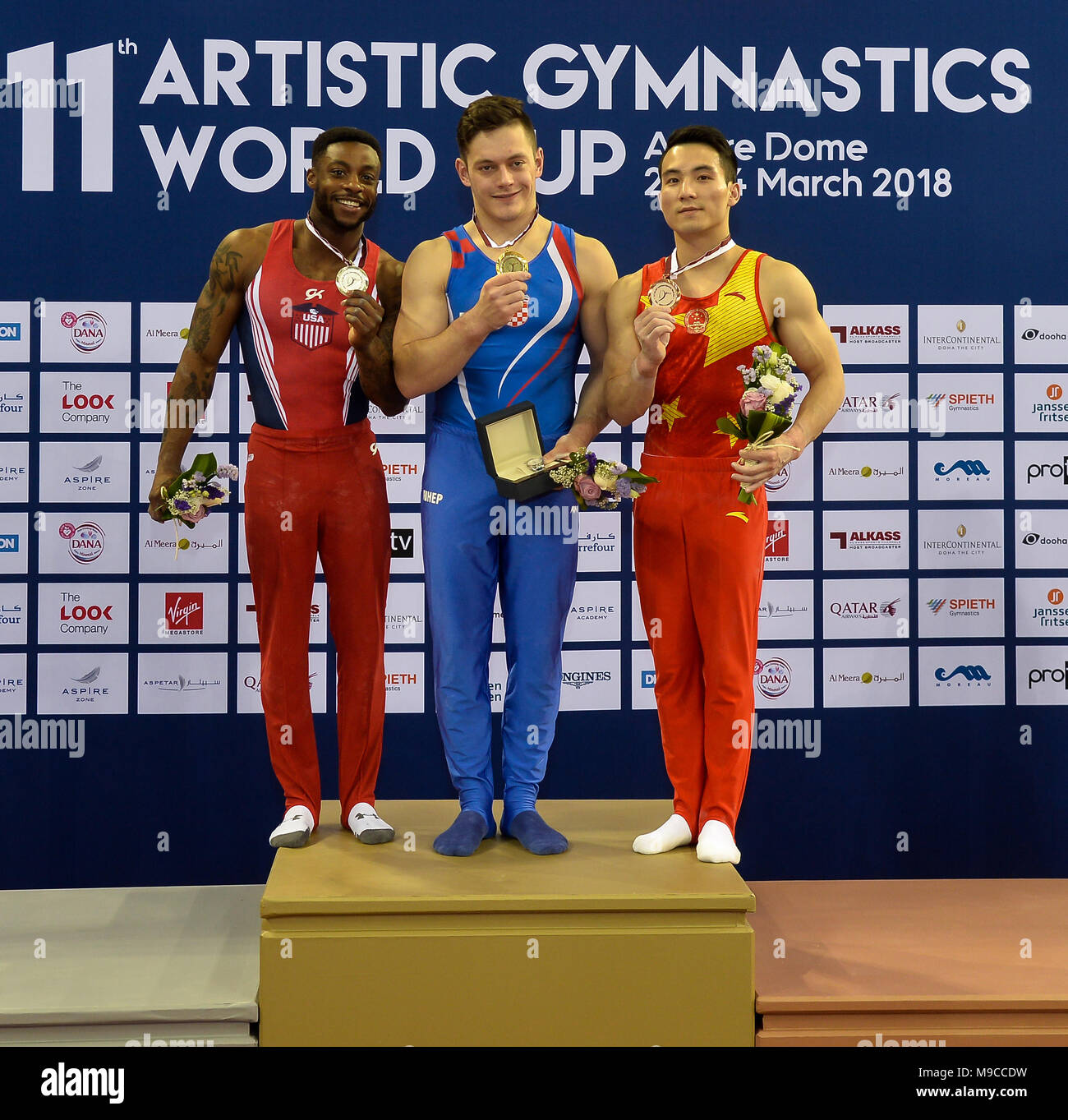 Doha, Capital of Qatar. 24th Mar, 2018. Gold medalist Tin Srbic (C) of Croatia, silver medalist Marvin Kimble (L) of the United States and bronze medalist Deng Shudi of China pose during the awarding ceremony for the Men's Horizontal Bar final at the 11th FIG Artistic Gymnastics Individual Apparatus World Cup in Doha, Capital of Qatar, on March 24, 2018. Credit: Nikku/Xinhua/Alamy Live News Stock Photo