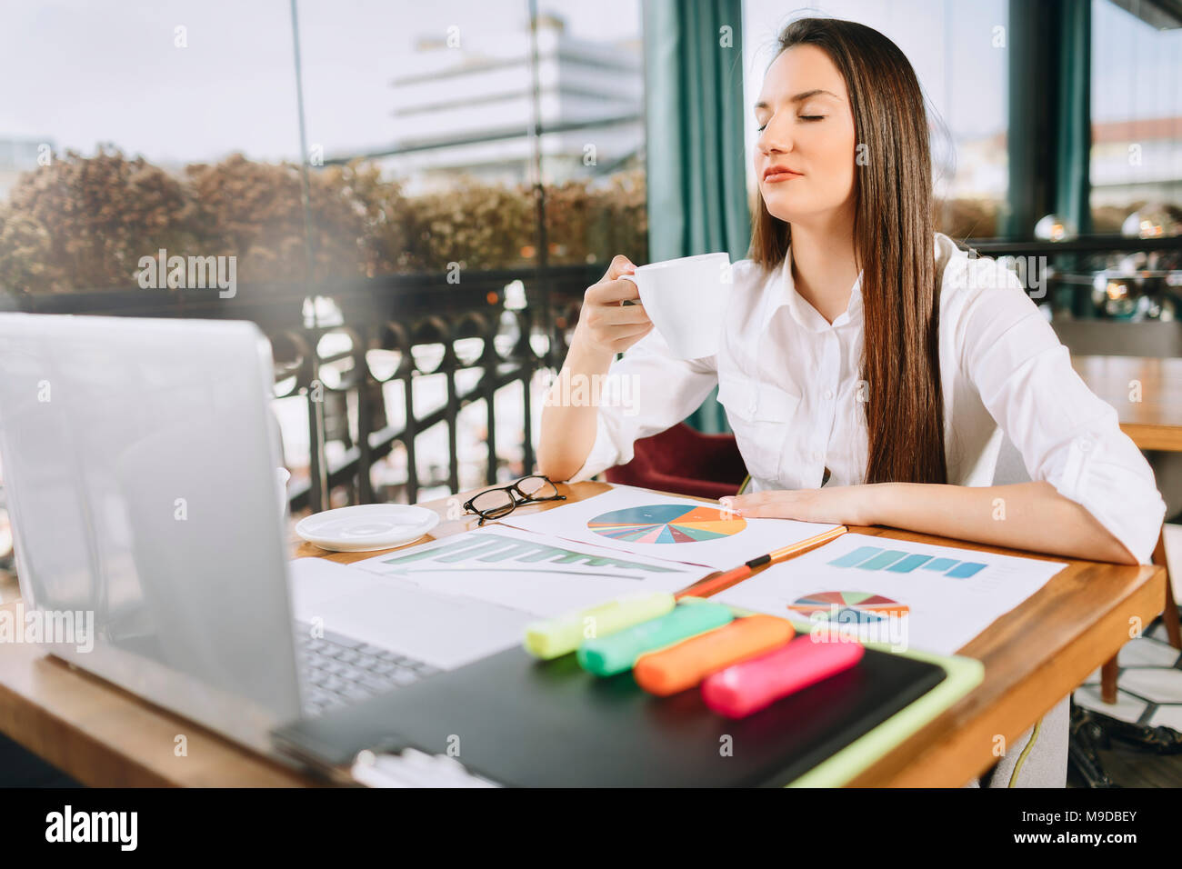 Businesswoman or young female with glasses making coffee pause at job. Coffee relaxation concept. Stock Photo