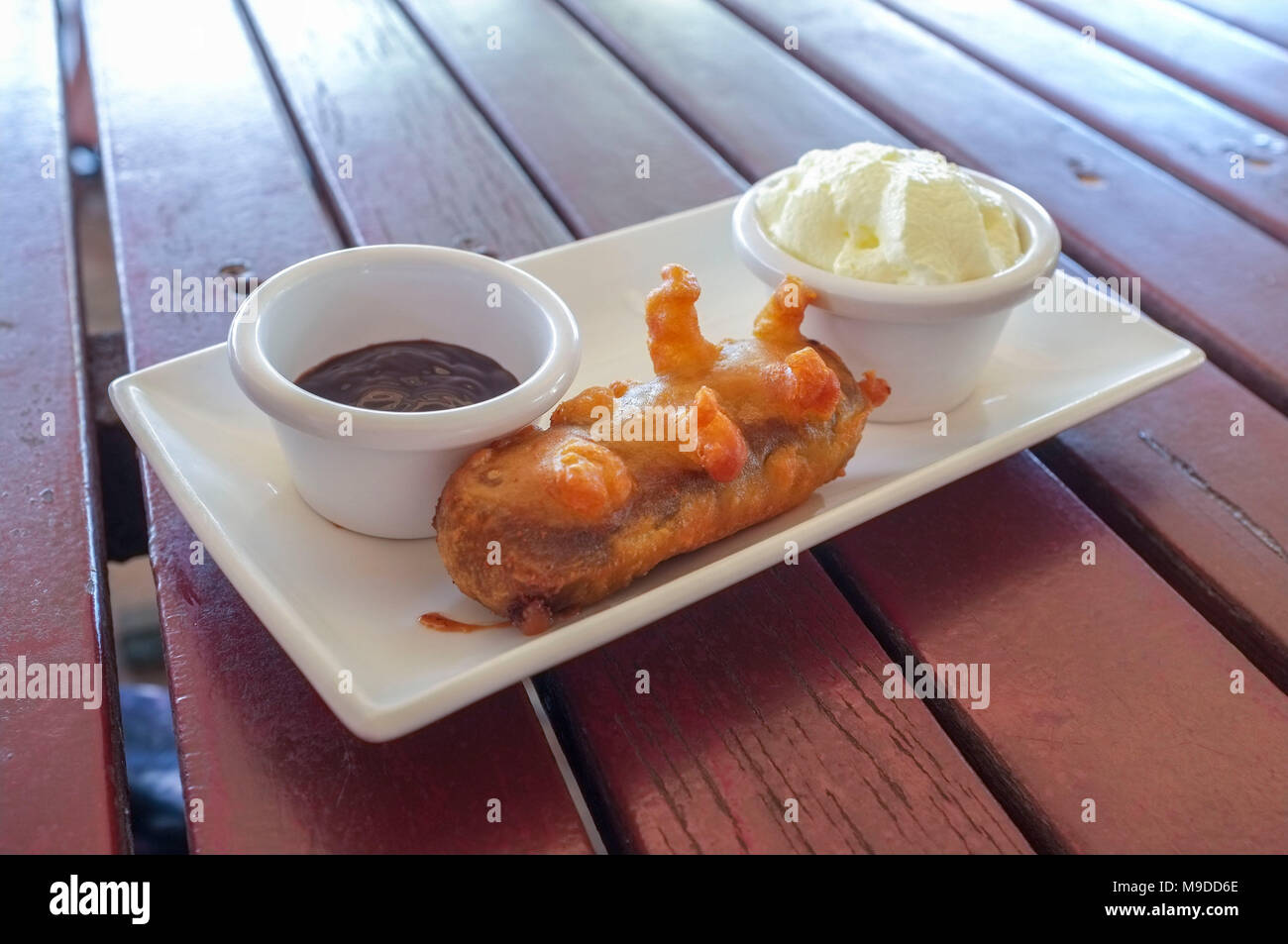 Deep fried Mars bar with chocolate sauce and whipped cream on the side
